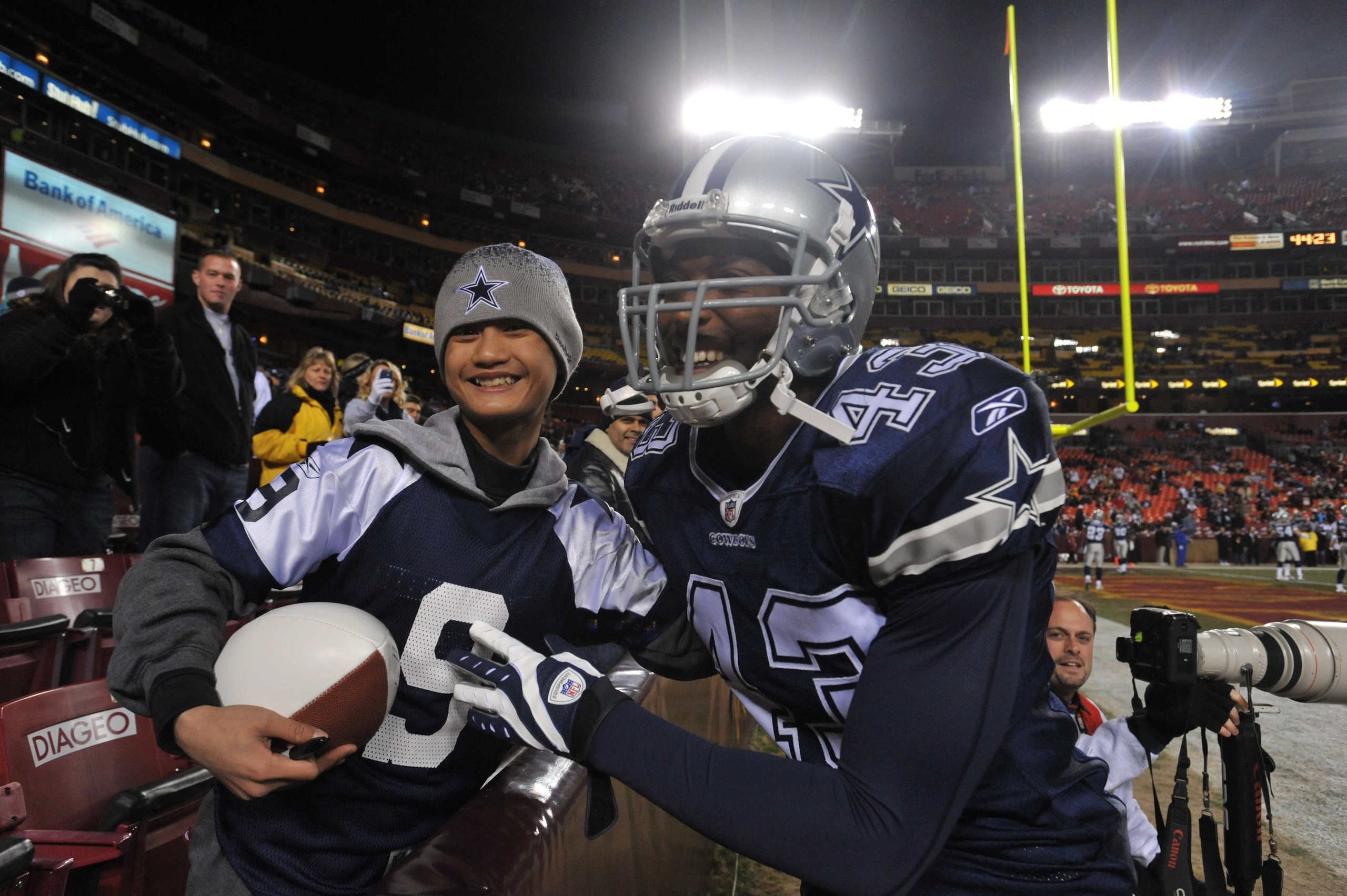 LANDOVER, MD - DECEMBER 27:  Gerald Sensabaugh #43 of the Dallas Cowboys poses with a fan before the game against the Washington Redskins at FedExField on December 27, 2009 in Landover, Maryland. The Cowboys defeated the Redskins 17-0. (Photo by Larry Fre