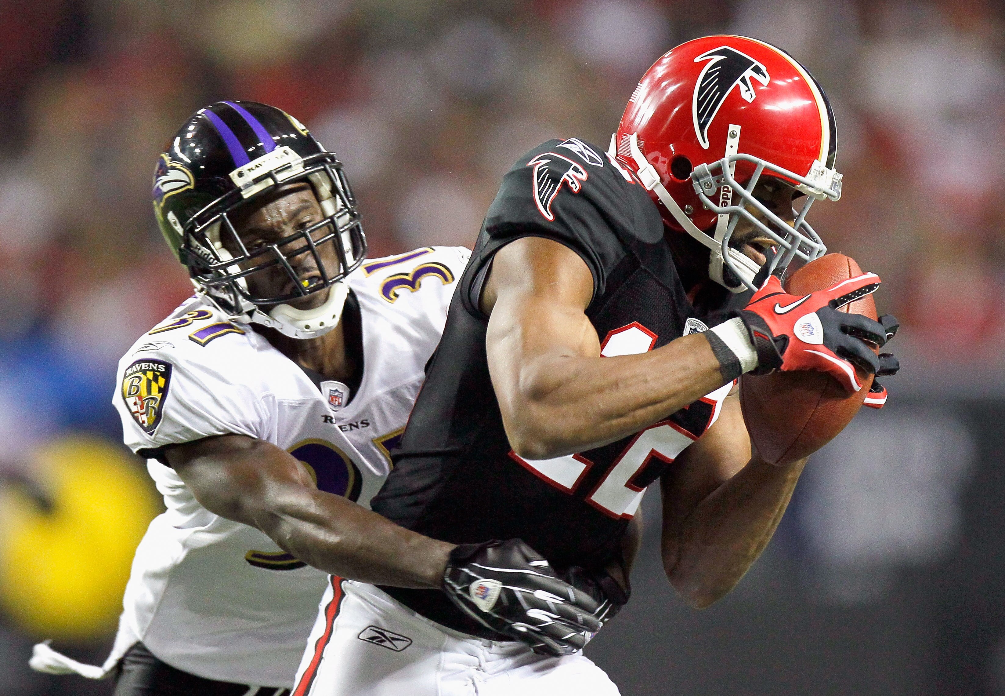 ATLANTA - NOVEMBER 11:  Michael Jenkins #12 of the Atlanta Falcons pulls in this reception against Fabian Washington #31 of the Baltimore Ravens at Georgia Dome on November 11, 2010 in Atlanta, Georgia.  (Photo by Kevin C. Cox/Getty Images)