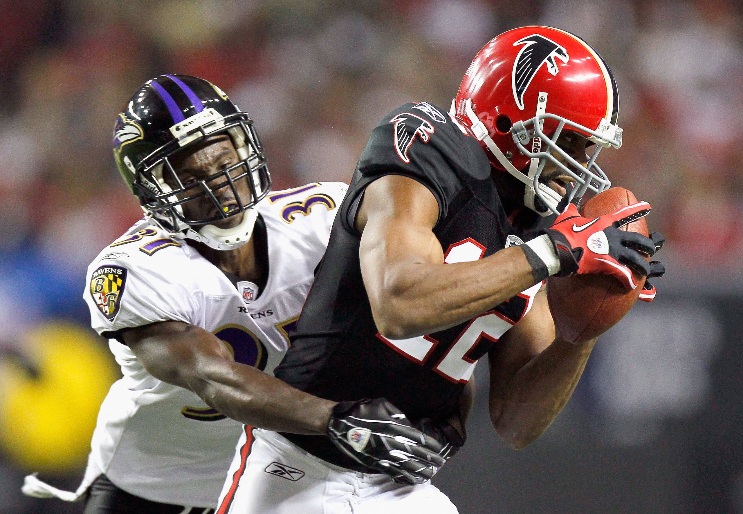 ATLANTA - NOVEMBER 11:  Michael Jenkins #12 of the Atlanta Falcons pulls in this reception against Fabian Washington #31 of the Baltimore Ravens at Georgia Dome on November 11, 2010 in Atlanta, Georgia.  (Photo by Kevin C. Cox/Getty Images)