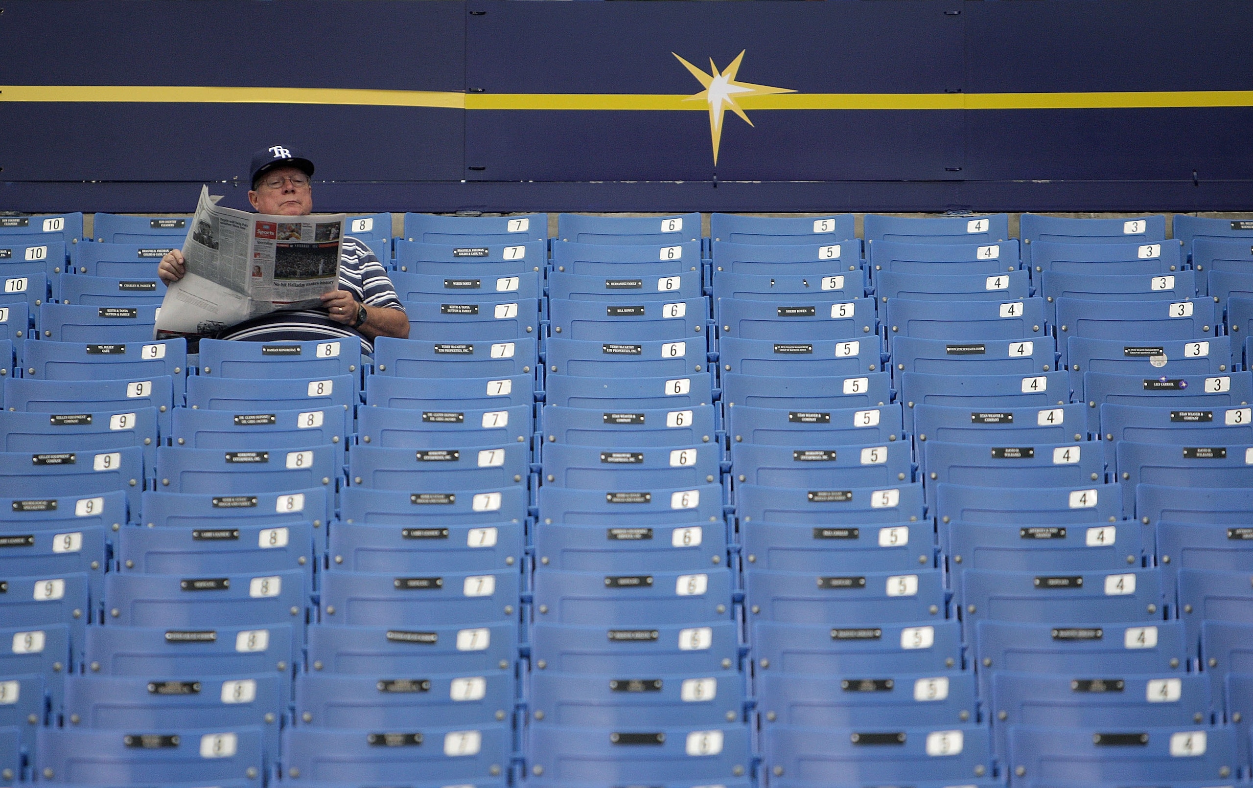 ST PETERSBURG, FL - OCTOBER 07:  A Tampa Bay Rays fan reads the paper before Game 2 of the ALDS between the Tampa Bay Rays and the Texas Rangers at Tropicana Field on October 7, 2010 in St. Petersburg, Florida.  (Photo by Mike Ehrmann/Getty Images)
