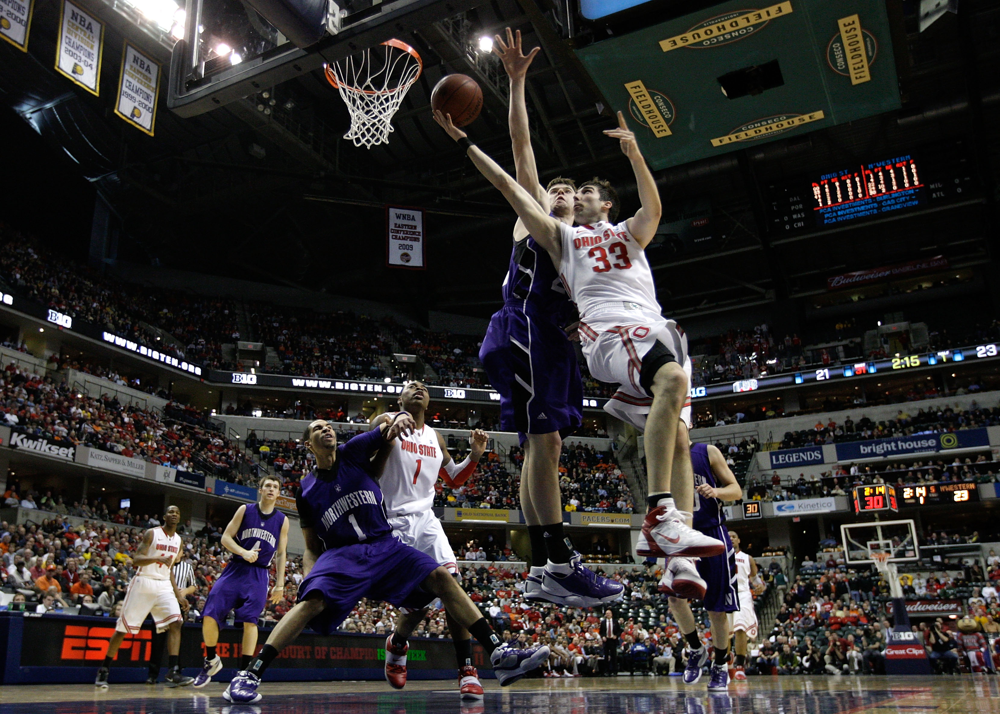 INDIANAPOLIS, IN - MARCH 11:  Jon Diebler #33 of the Ohio State Buckeyes drives for a shot attempt against John Shurna #24 of the Northwestern Wildcats during the quarterfinals of the 2011 Big Ten Men's Basketball Tournament at Conseco Fieldhouse on March