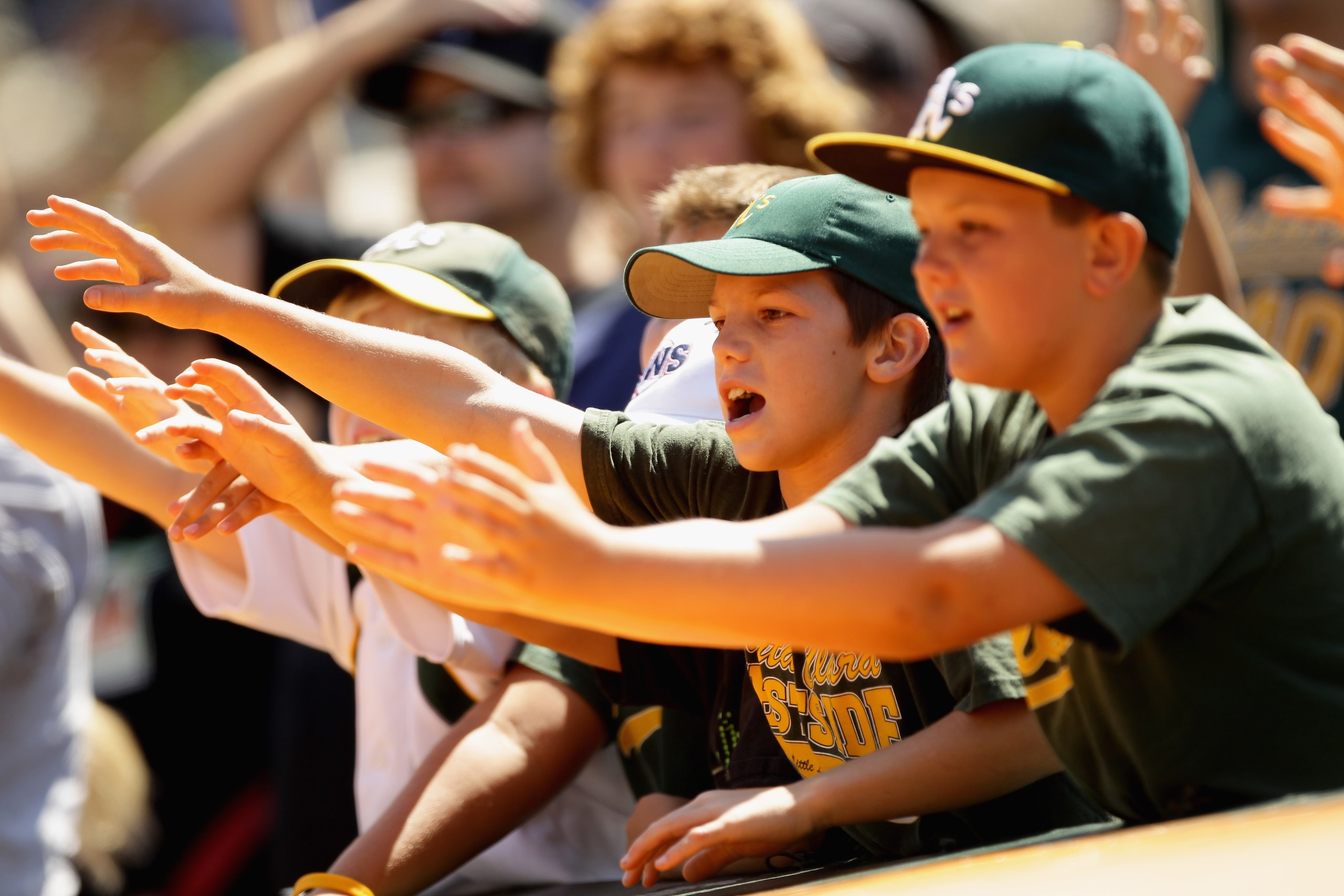 OAKLAND, CA - AUGUST 07:  Fans for the Oakland Athletics try to get a ball during their game against the Texas Rangers at the Oakland-Alameda County Coliseum on August 7, 2010 in Oakland, California.  (Photo by Ezra Shaw/Getty Images)