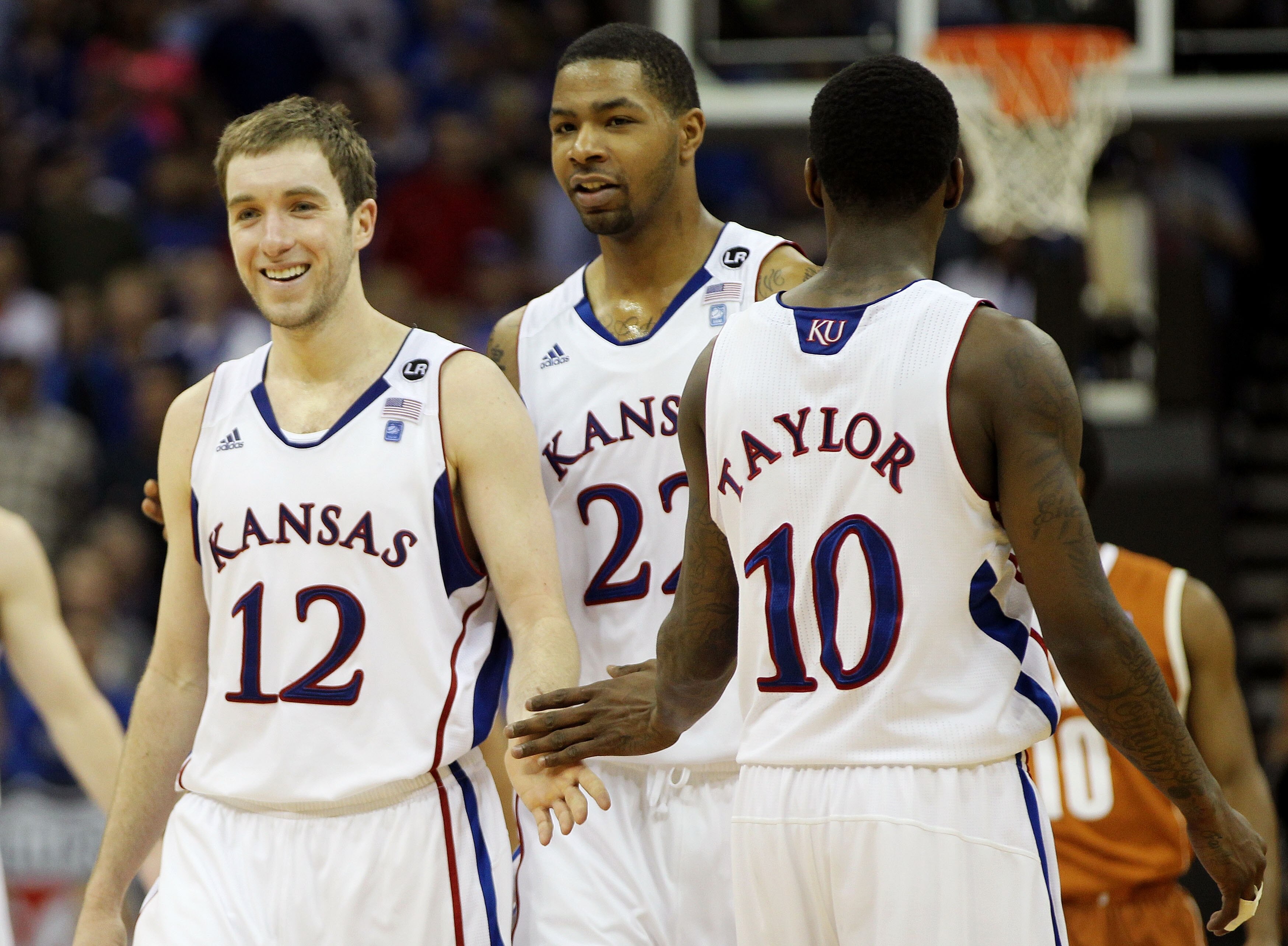 KANSAS CITY, MO - MARCH 12:  Brady Morningstar #12, Marcus Morris #22 and Tyshawn Taylor #10 of the Kansas Jayhawks react after a play against the Texas Longhorns during the 2011 Phillips 66 Big 12 Men's Basketball Tournament championship game at Sprint C