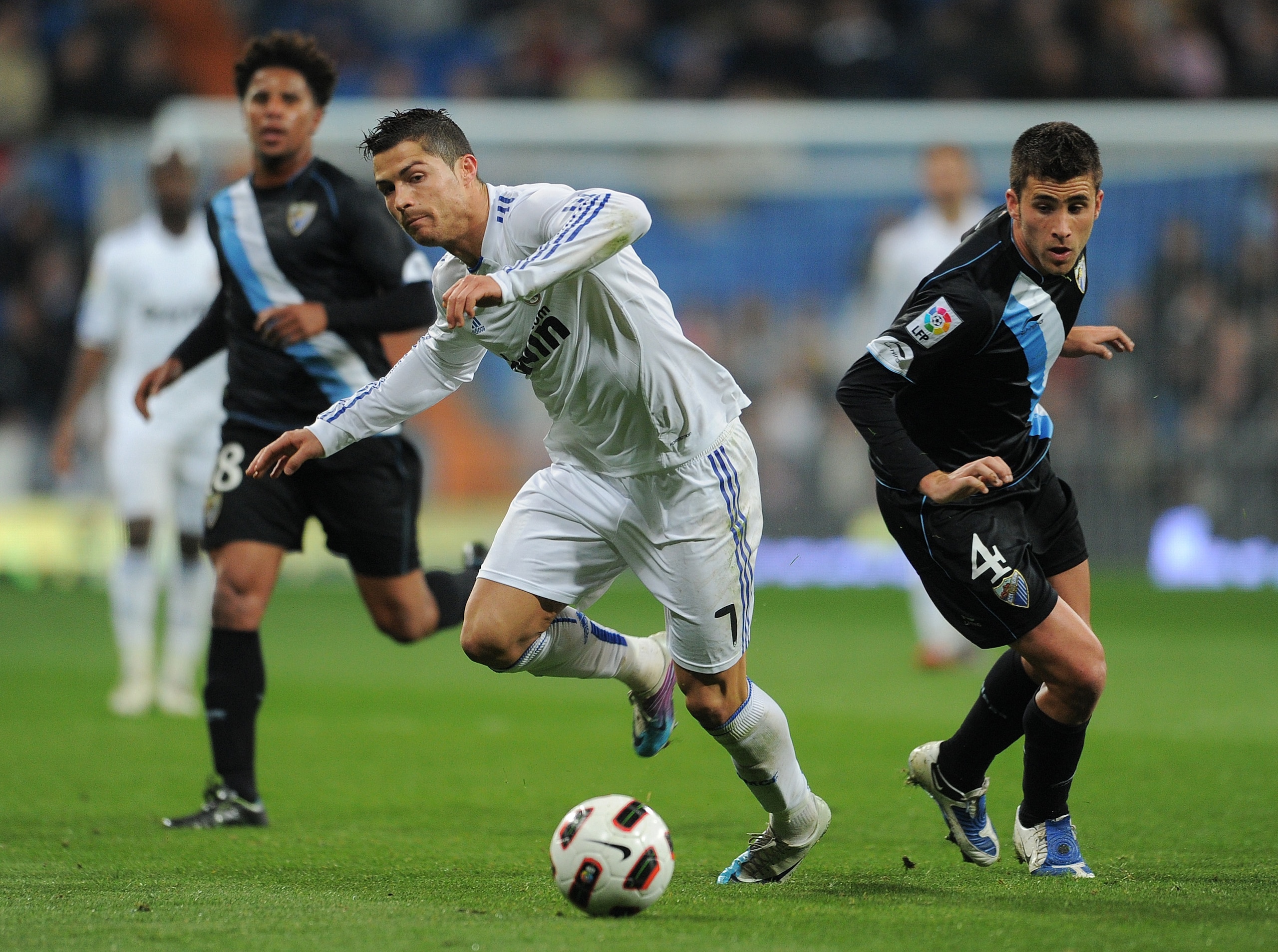 MADRID, SPAIN - MARCH 03:  Cristiano Ronaldo (L) of Real Madrid tries to keep his balance after being fouled by Manu Torres of Malaga during the la Liga match between Real Madrid and Malaga at Estadio Santiago Bernabeu on March 3, 2011 in Madrid, Spain.
