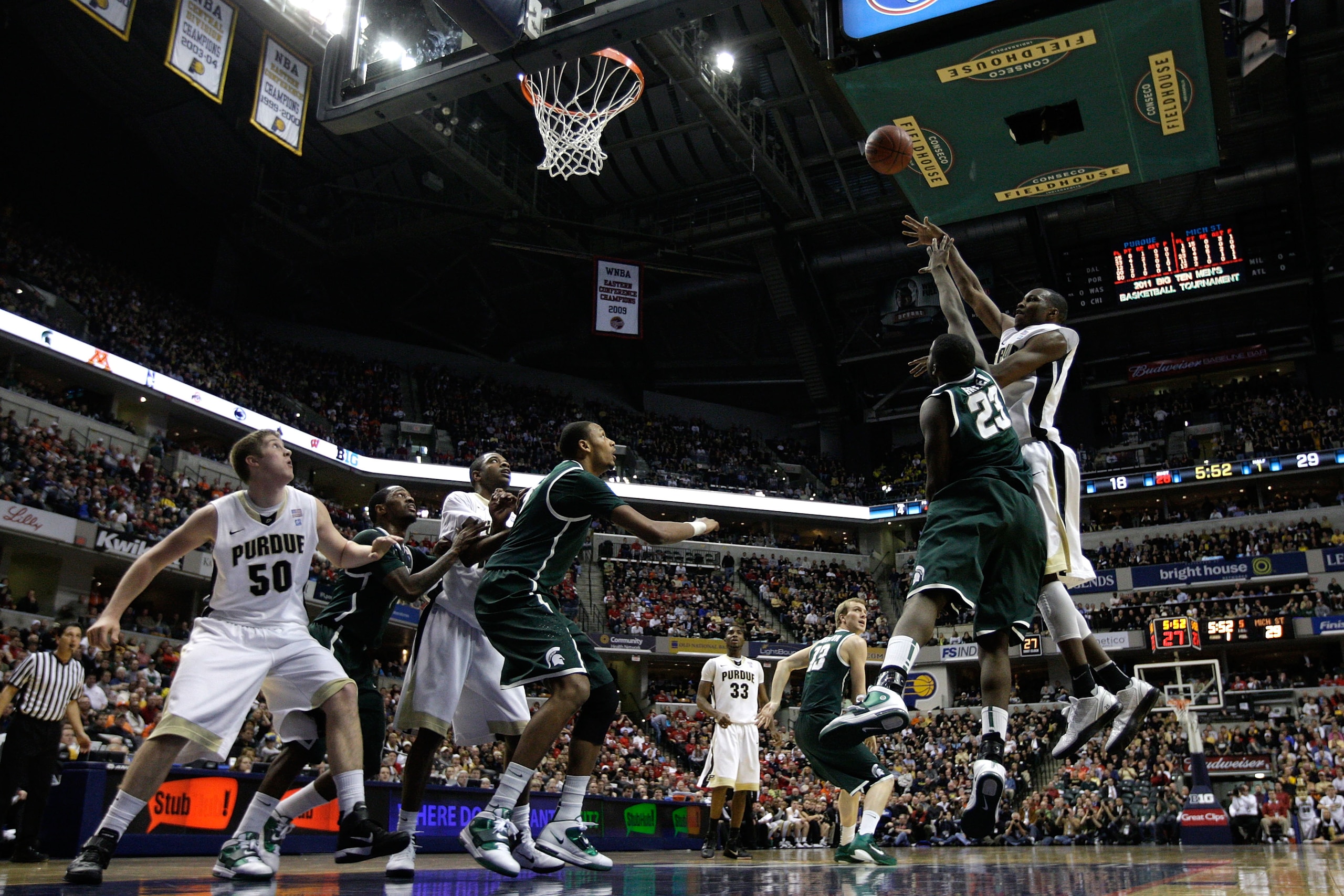 INDIANAPOLIS, IN - MARCH 11:  JaJuan Johnson #25 of the Purdue Boilermakers attempts a shot in the first half against Draymond Green #23 of the Michigan State Spartans during the quarterfinals of the 2011 Big Ten Men's Basketball Tournament at Conseco Fie