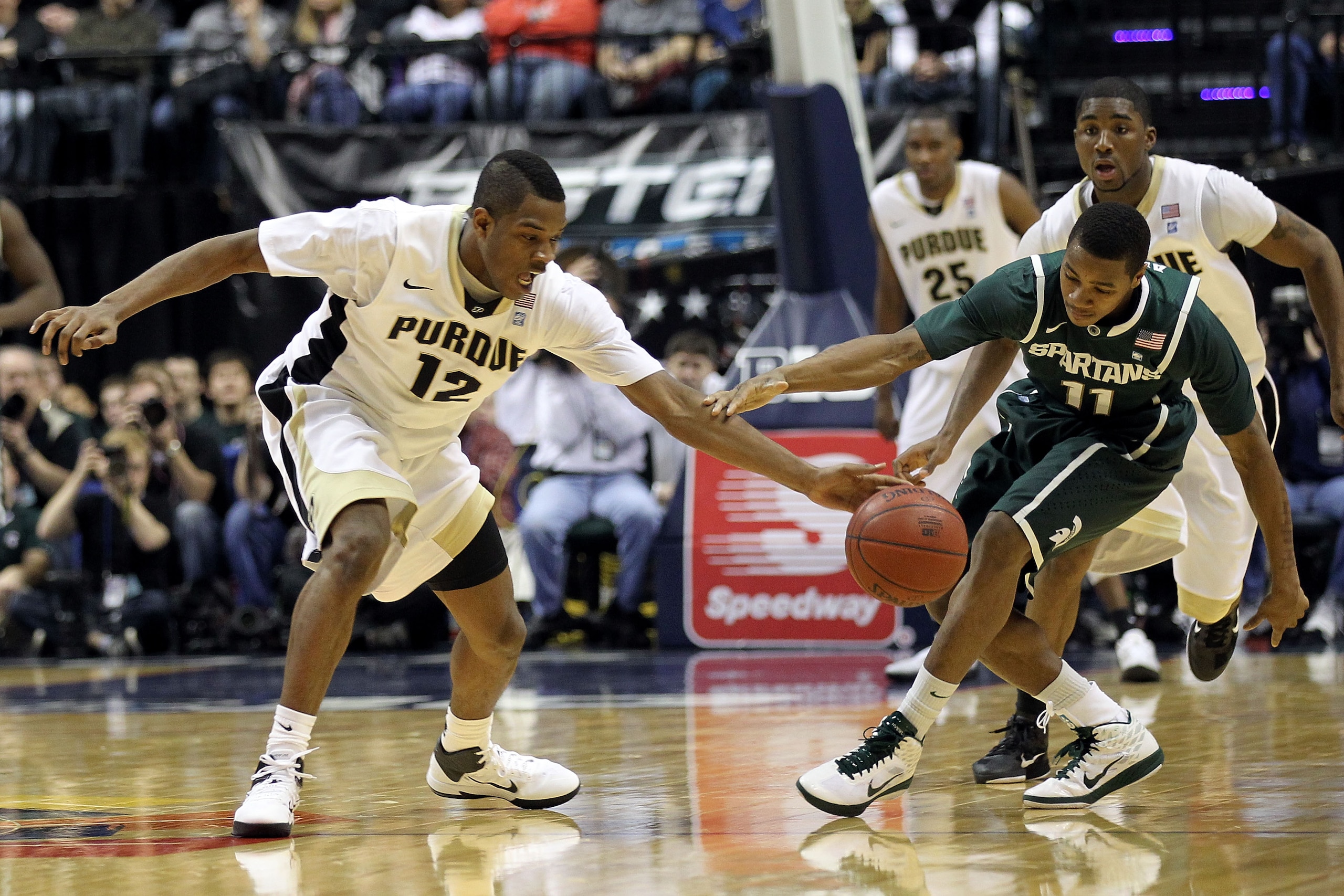 INDIANAPOLIS, IN - MARCH 11:  Kelsey Barlow #12 of the Purdue Boilermakers fights for a loose ball against Keith Appling #11 of the Michigan State Spartans during the quarterfinals of the 2011 Big Ten Men's Basketball Tournament at Conseco Fieldhouse on M