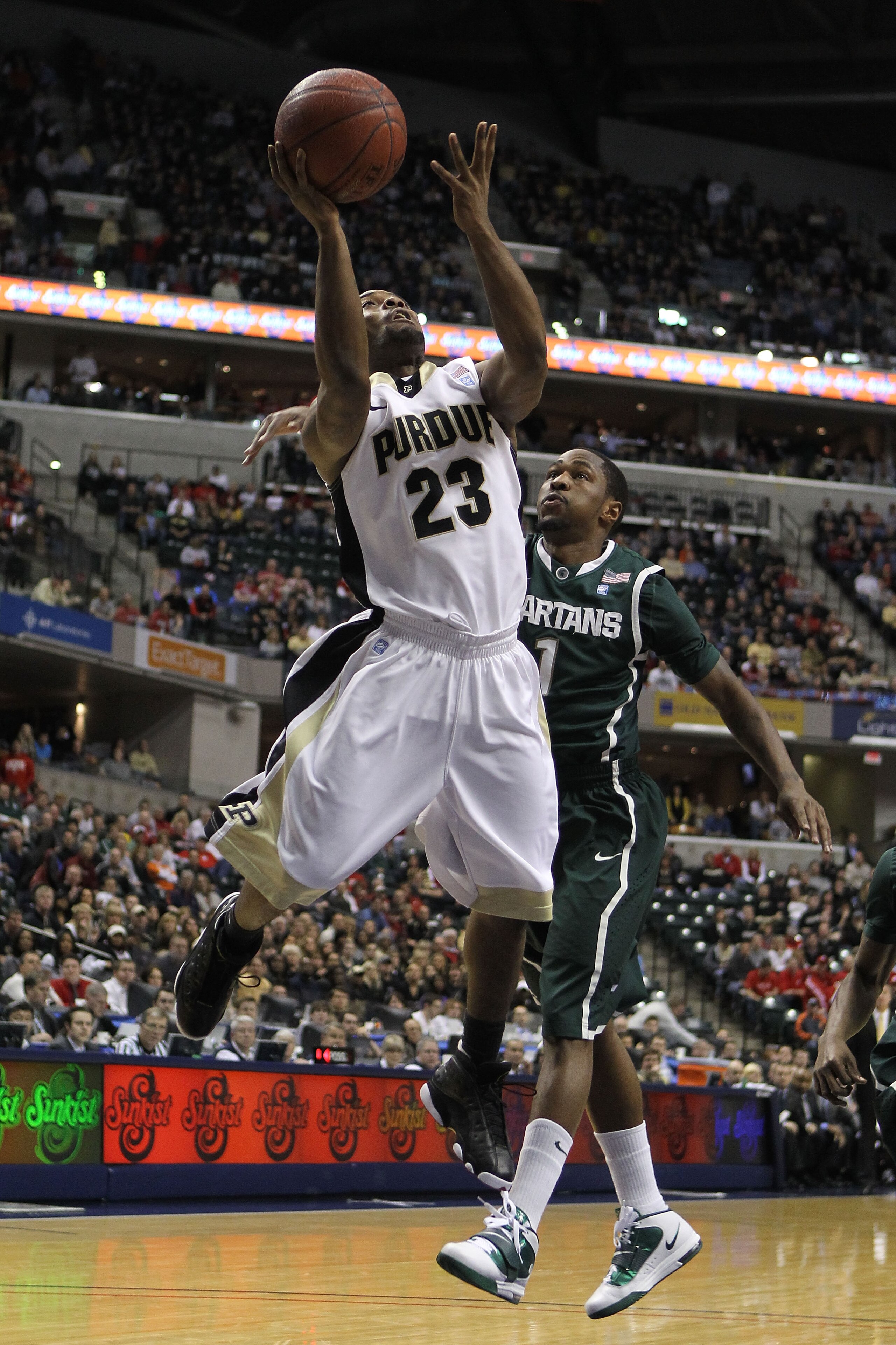 INDIANAPOLIS, IN - MARCH 11:  Lewis Jackson #23 of the Purdue Boilermakers drives for a shot attempt against Kalin Lucas #1 of the Michigan State Spartans during the quarterfinals of the 2011 Big Ten Men's Basketball Tournament at Conseco Fieldhouse on Ma