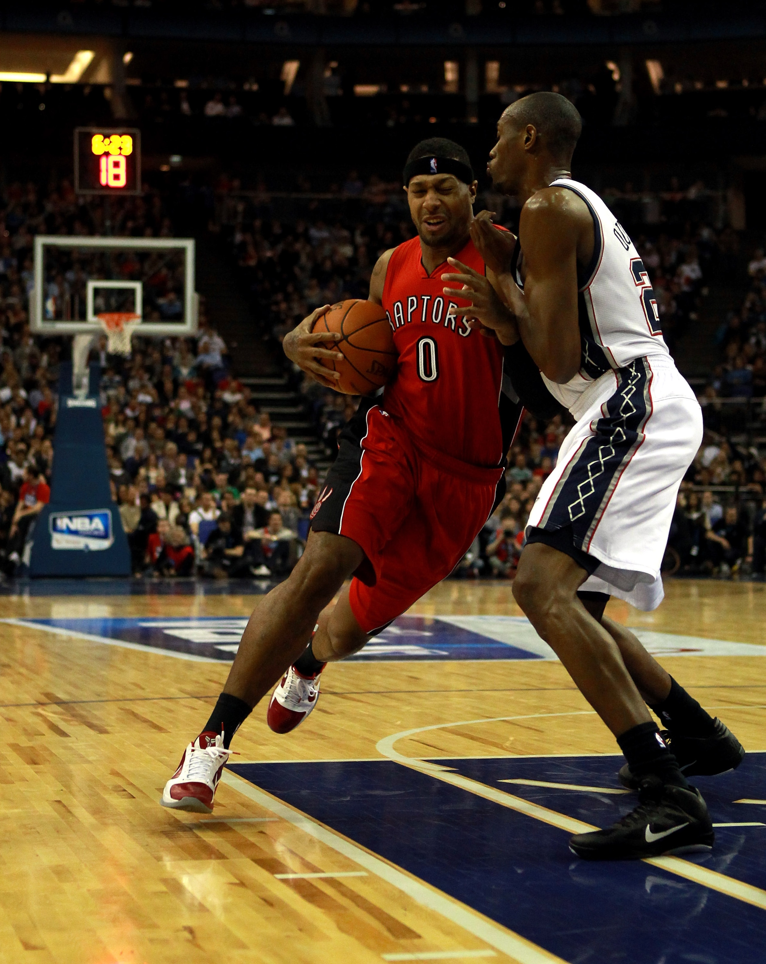 LONDON, ENGLAND - MARCH 04:  James Johnson #0 of the Raptors fends off Travis Outlaw #21 of the Nets during the NBA match between New Jersey Nets and the Toronto Raptors at the O2 Arena on March 4, 2011 in London, England. NOTE TO USER: User expressly ack