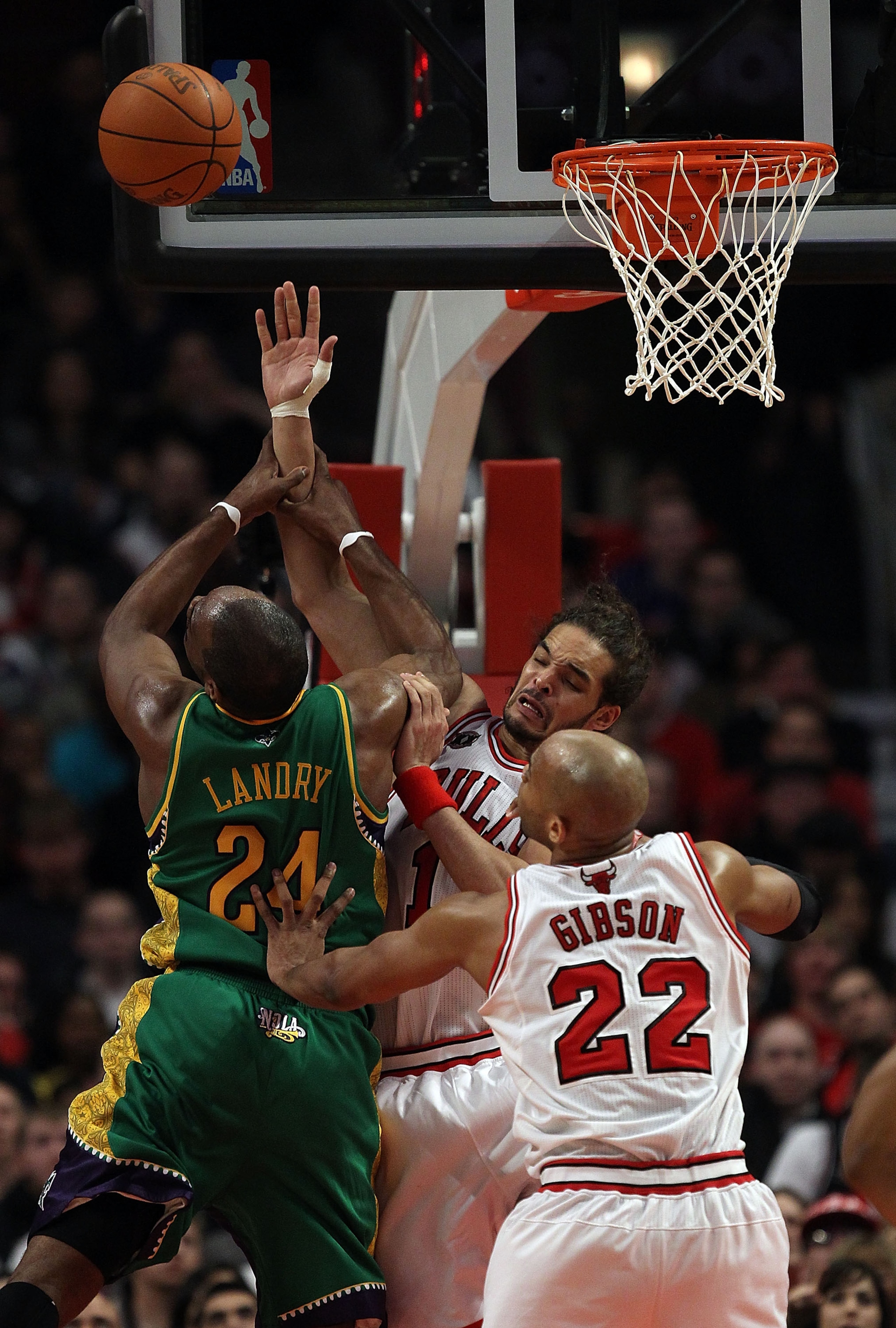 CHICAGO, IL - MARCH 07: Joakim Noah #13 and Taj Gibson #22 of the Chicago Bulls pressure Carl Landry #24 of the New Orleans Hornets as he shoots at the United Center on March 7, 2011 in Chicago, Illinois. The Bulls defeated the Hornets 85-77. NOTE TO USER