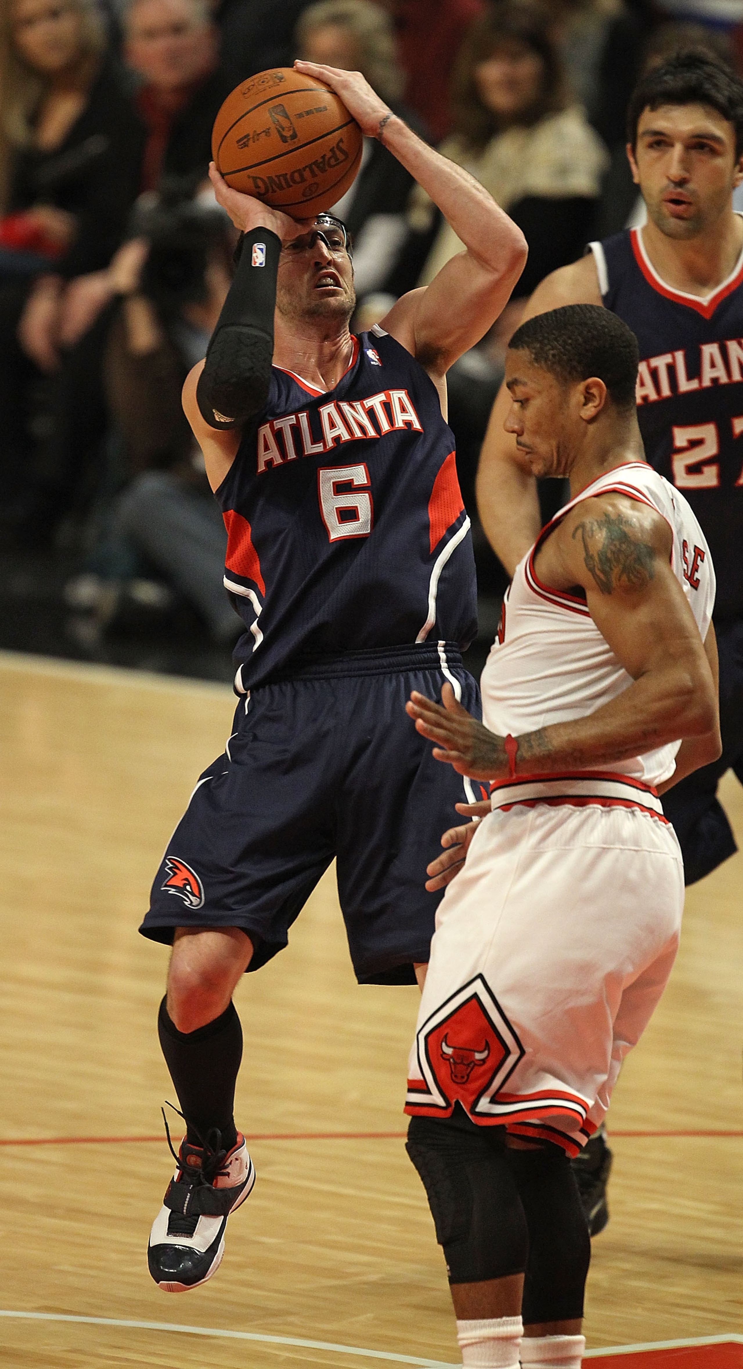 CHICAGO, IL - MARCH 11: Kirk Hinrich #6 of the Atlanta Hawks puts up a shot over Derrick Rose #1 of the Chicago Bulls at the United Center on March 11, 2011 in Chicago, Illinois. NOTE TO USER: User expressly acknowledges and agrees that, by downloading an