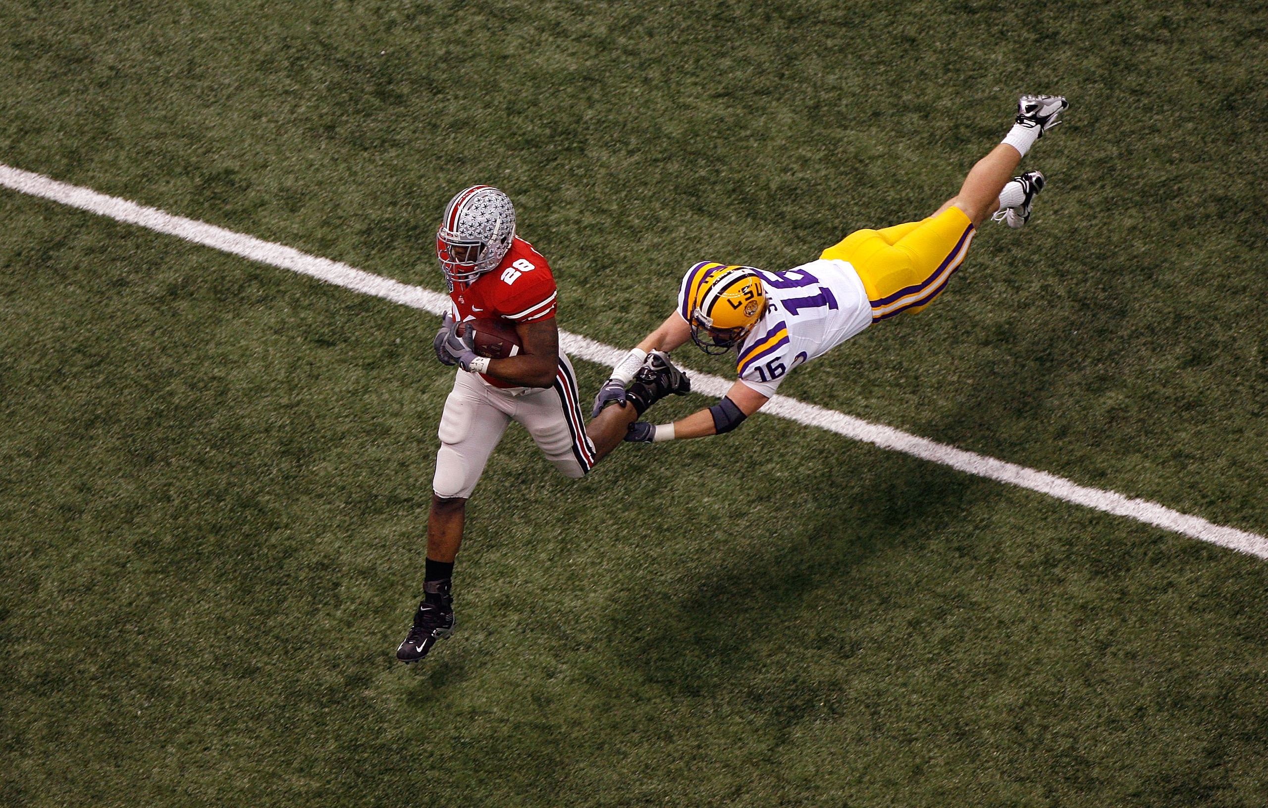 NEW ORLEANS - JANUARY 07:  Chris Wells #28 of the Ohio State Buckeyes runs for a 65-yard touchdown in the first quarter against Craig Steltz #16 of the Louisiana State University Tigers during the AllState BCS National Championship on January 7, 2008 at t