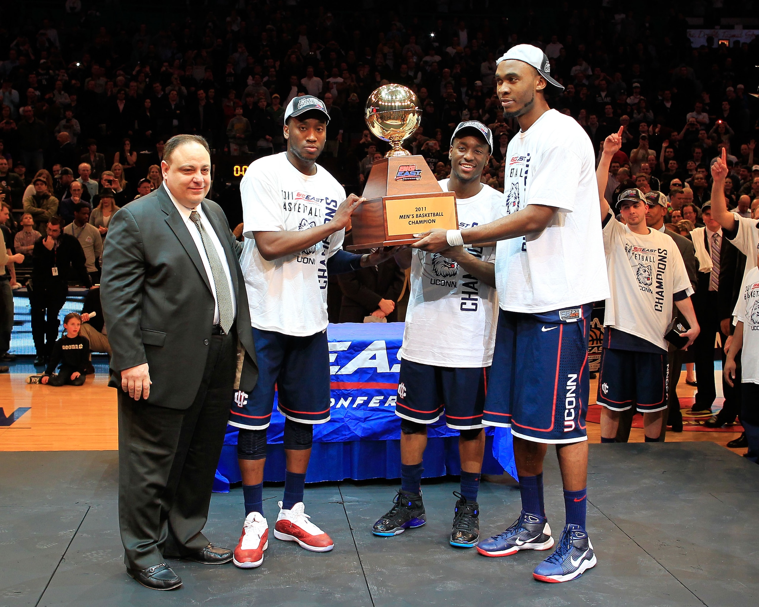NEW YORK, NY - MARCH 12: Donnell Beverly #2, Kemba Walker #15 and Charles Okwandu #35 of the Connecticut Huskies hold up the Championship trophy after defeating the Louisville Cardinals during the championship of the 2011 Big East Men's Basketball Tourna NEW YORK, NY - MARCH 12: Donnell Beverly #2, Kemba Walker #15 and Charles Okwandu #35 of the Connecticut Huskies hold up the Championship trophy after defeating the Louisville Cardinals during the championship of the 2011 Big East Men's Basketball Tourna