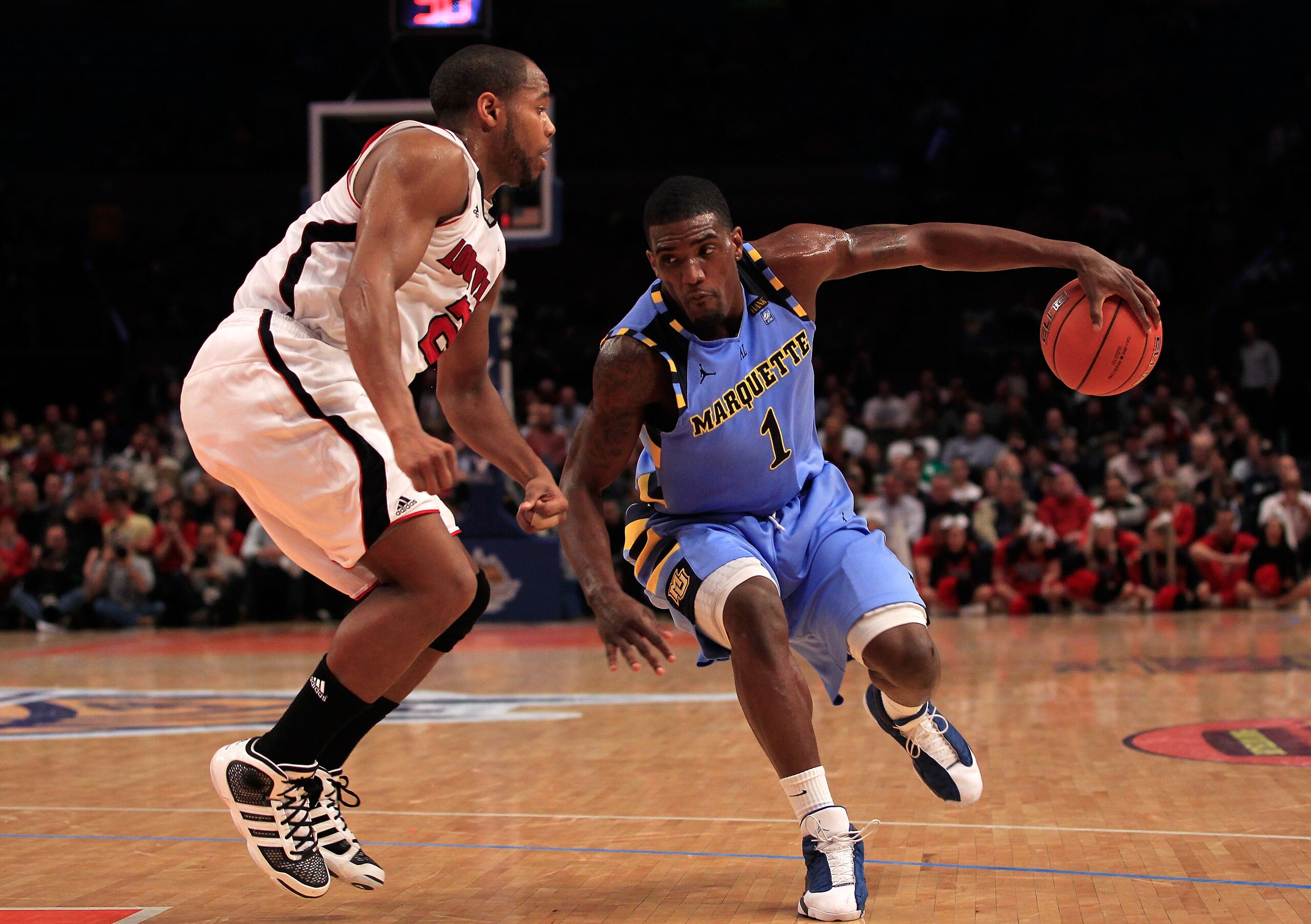 NEW YORK, NY - MARCH 10: Darius Johnson-Odom #1 of the Marquette Golden Eagles handles the ball against Preston Knowles #2 of the Louisville Cardinals during the quarterfinals of the 2011 Big East Men's Basketball Tournament presented by American Eagle Ou