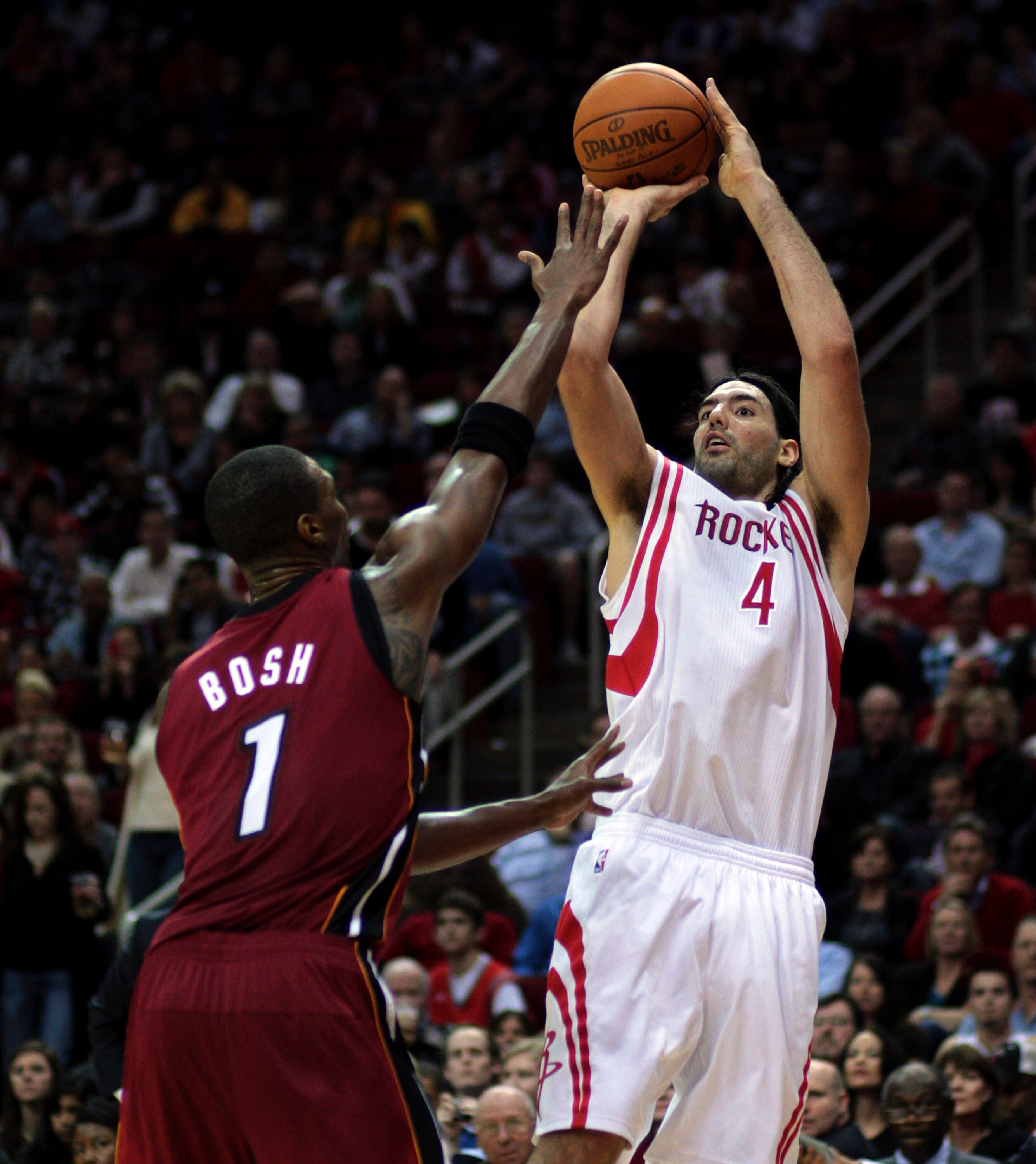 HOUSTON - DECEMBER 29:  Luis Scola #4 of the Houston Rockets shoots over Chris Bosh #1 of the Miami Heat during the fourth quarter at Toyota Center on December 29, 2010 in Houston, Texas. Miami won 125-119. NOTE TO USER: User expressly acknowledges and ag
