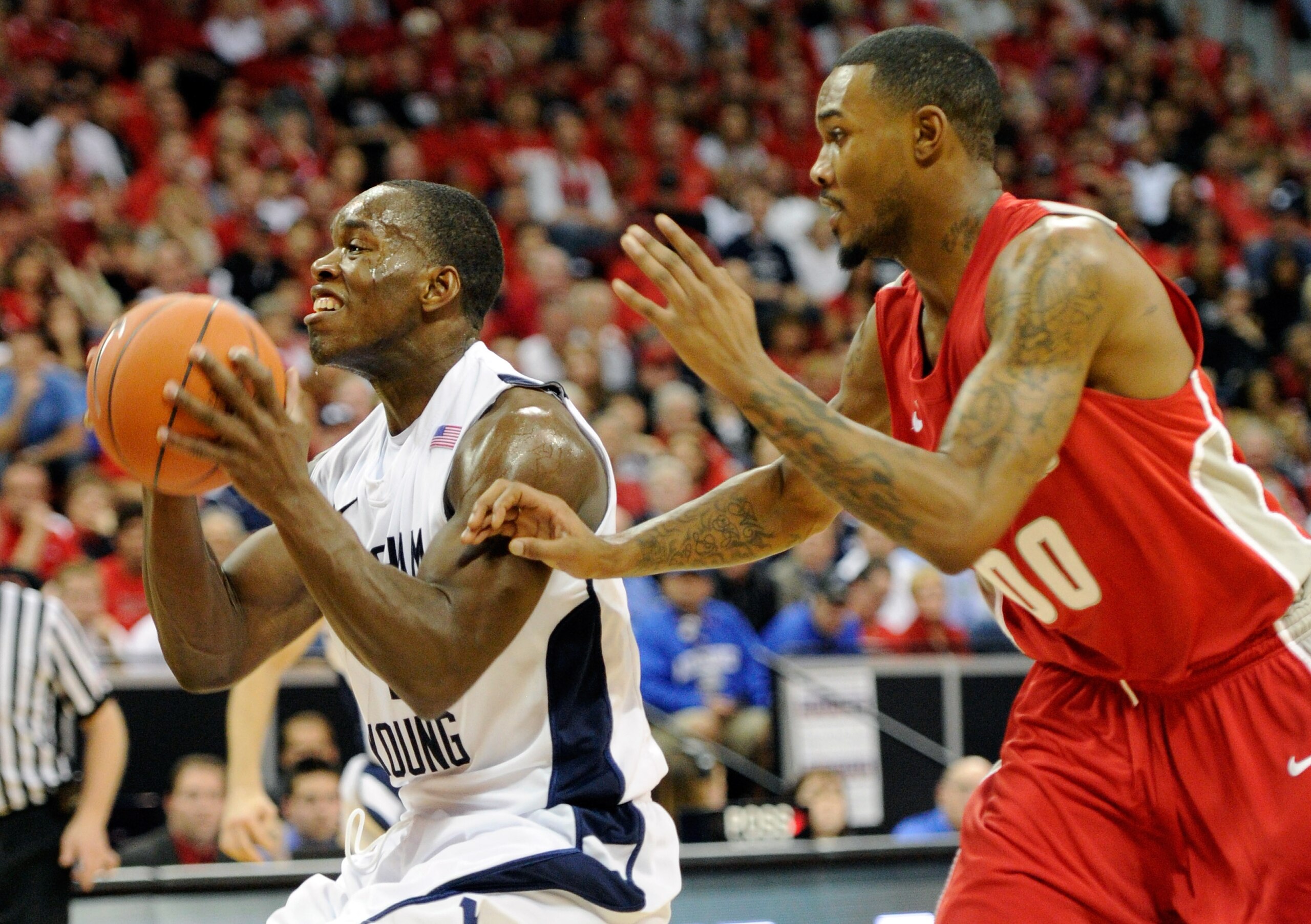 LAS VEGAS, NV - MARCH 11:  Charles Abouo #1 of the Brigham Young University Cougars drives ahead of A.J. Hardeman #00 of the New Mexico Lobos during a semifinal game of the Conoco Mountain West Conference Basketball tournament at the Thomas & Mack Center
