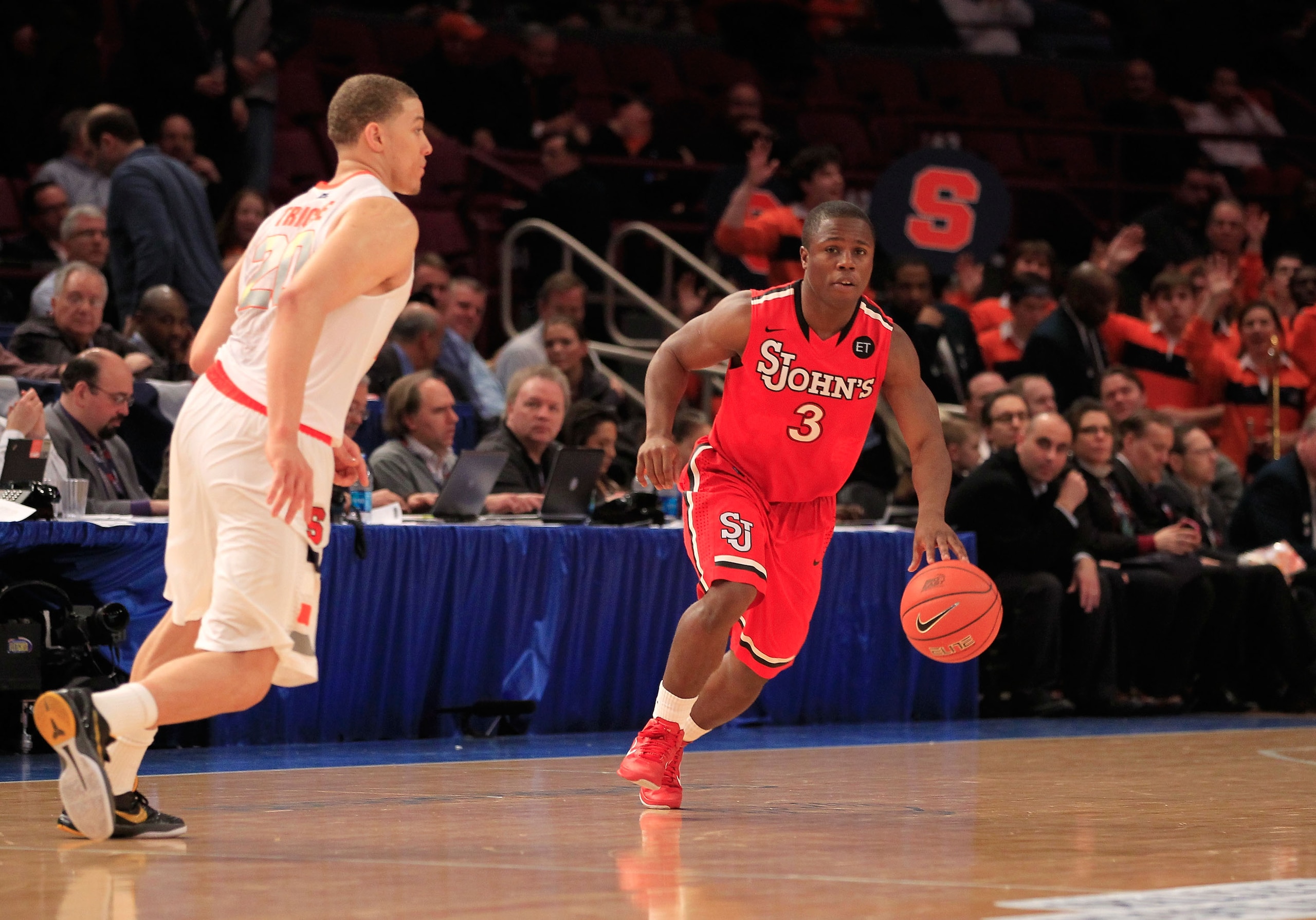 NEW YORK, NY - MARCH 10: Malik Boothe #3 of the St. John's Red Storm handles the ball against Brandon Triche #20 of the Syracuse Orange during the quarterfinals of the 2011 Big East Men's Basketball Tournament presented by American Eagle Outfitters  at Ma