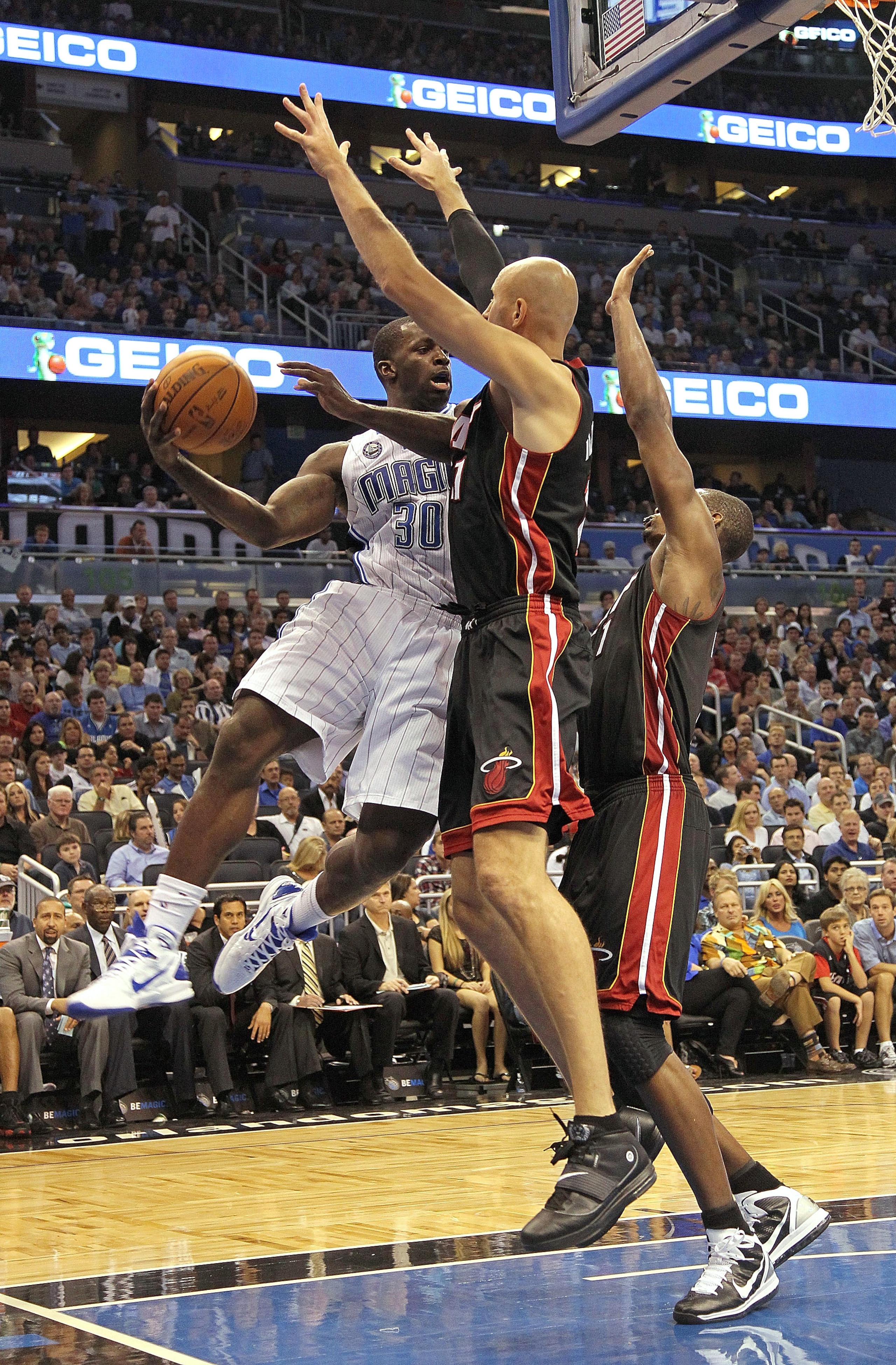 ORLANDO, FL - NOVEMBER 24:  Brandon Bass #30 of the Orlando Magic passes over Zydrunas Ilgauskas #11 of the Miami Heat during a game at Amway Arena on November 24, 2010 in Orlando, Florida. NOTE TO USER: User expressly acknowledges and agrees that, by dow