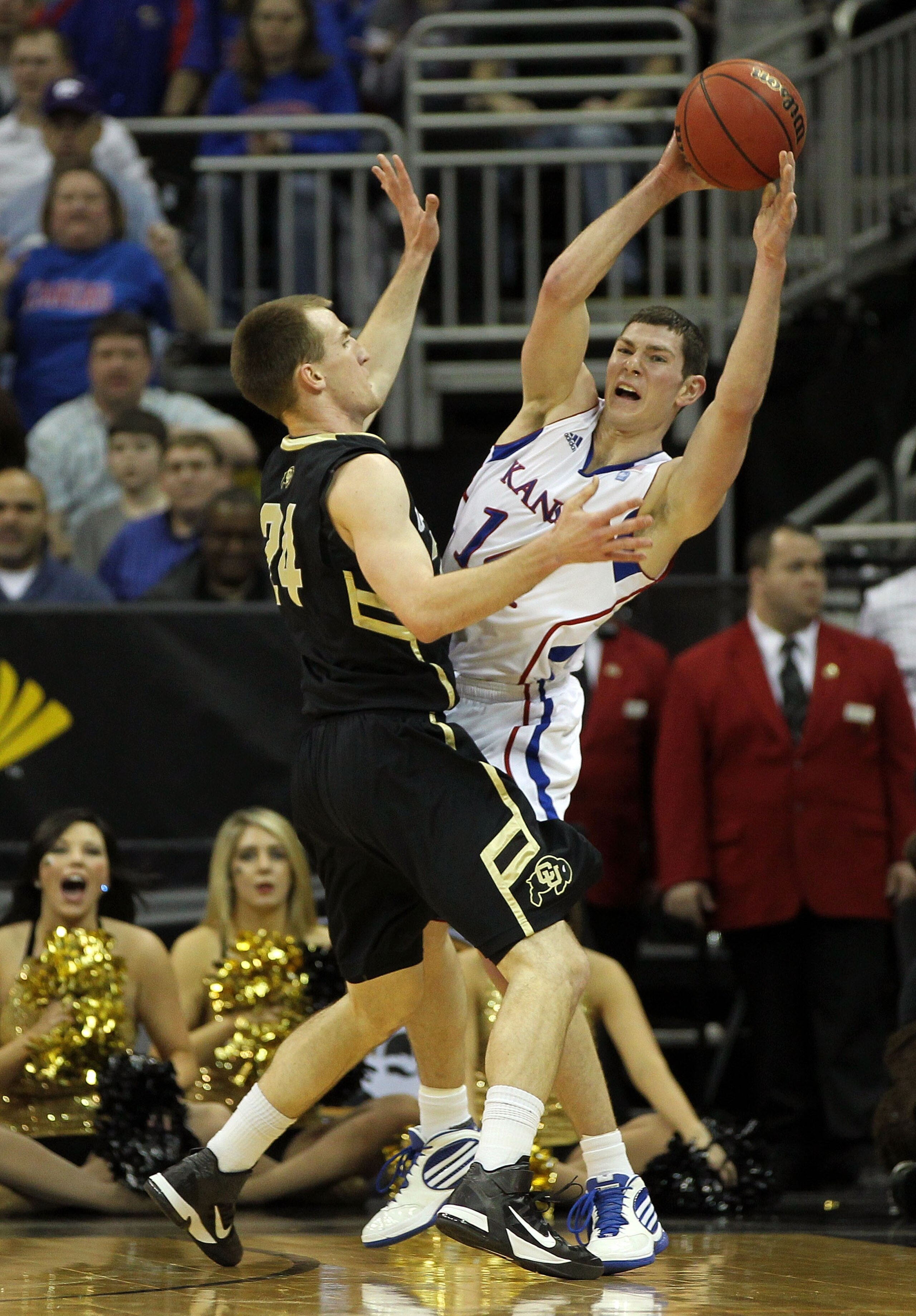 KANSAS CITY, MO - MARCH 11:  Tyrel Reed #14 of the Kansas Jayhawks looks to pass as Levi Knutson #24 of the Colorado Buffaloes defends during their semifinal game in the 2011 Phillips 66 Big 12 Men's Basketball Tournament at Sprint Center on March 11, 201