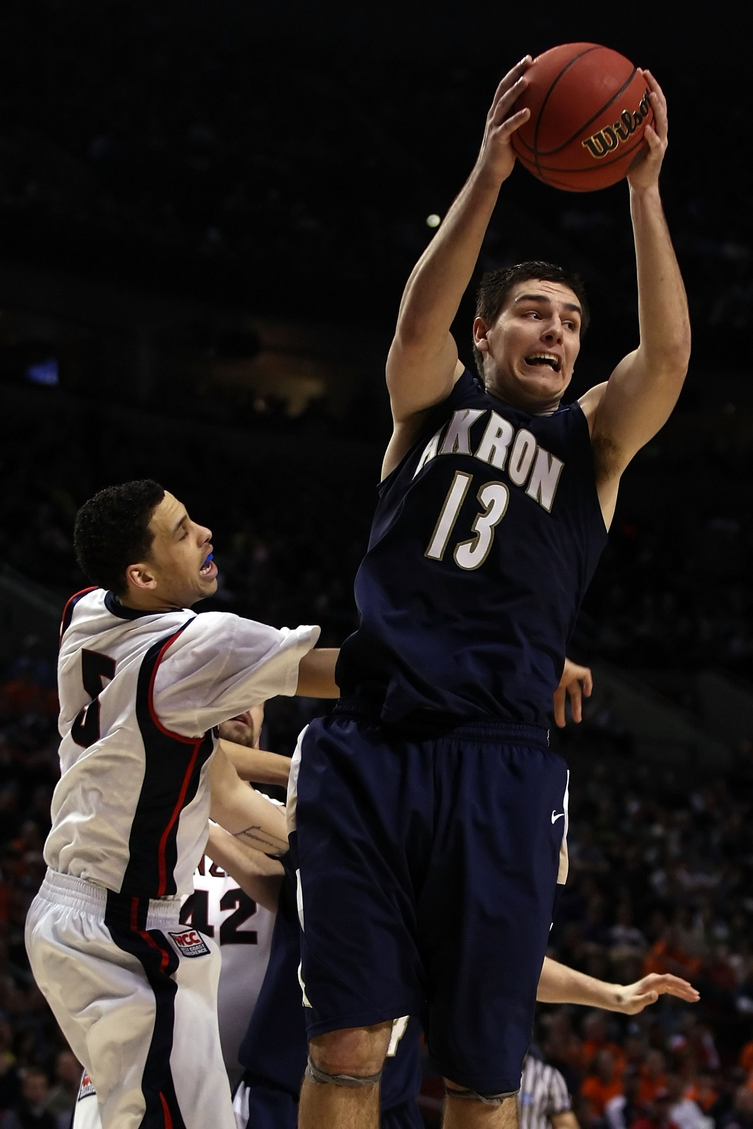 PORTLAND, OR - MARCH 19:  Nikola Cvetinovic #13 of the Akron Zips grabs a rebound against Austin Daye #5 of the Gonzaga Bulldogs in the second half during the first round of the NCAA Division I Men's Basketball Tournament at the Rose Garden on March 19, 2