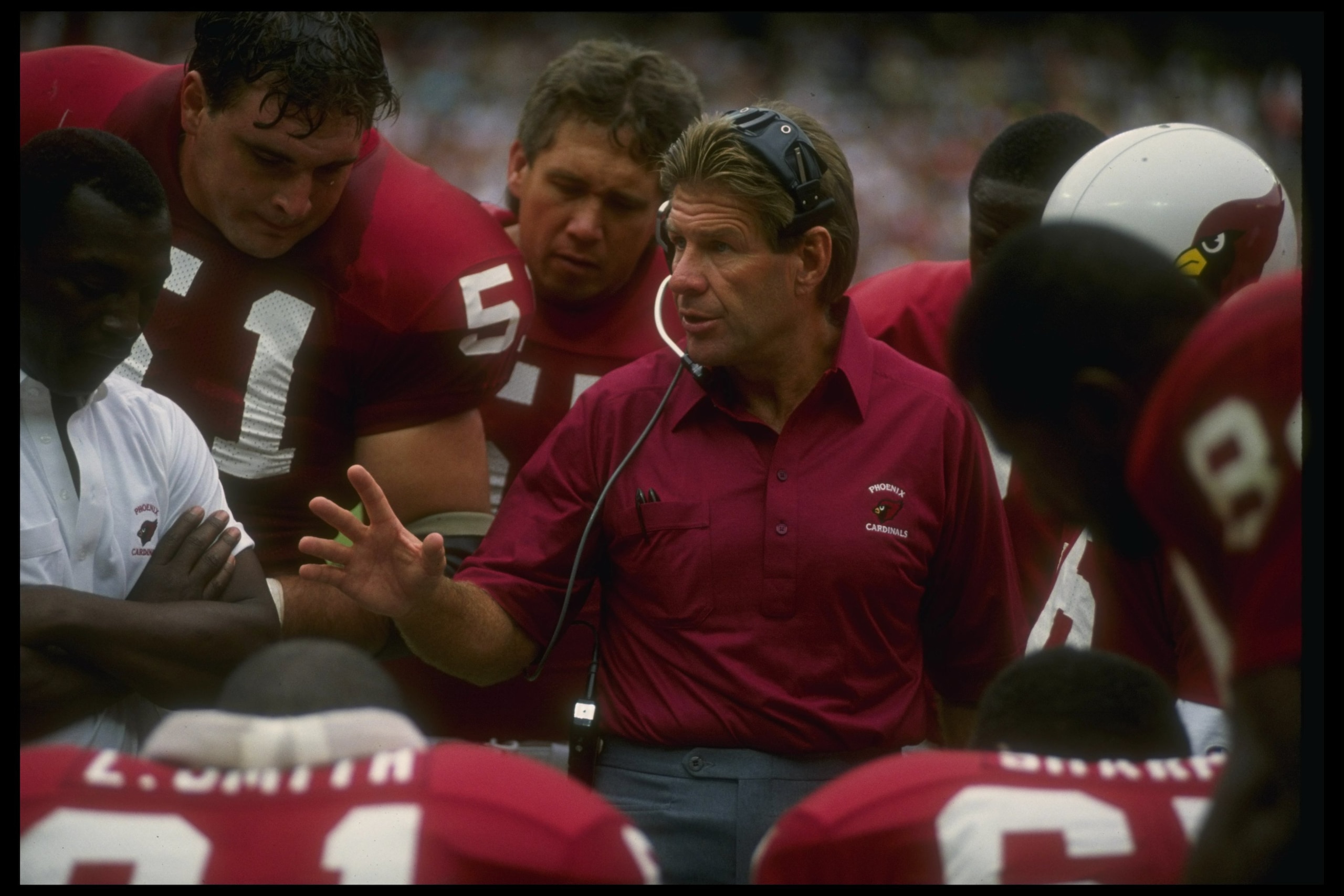 9 Sep 1990: Phoenix Cardinals head coach Joe Bugel confers with his team during a game against the Washington Redskins at Sun Devil Stadium in Tempe, Arizona. The Redskins won the game, 31-0. 9 Sep 1990: Phoenix Cardinals head coach Joe Bugel confers with his team during a game against the Washington Redskins at Sun Devil Stadium in Tempe, Arizona. The Redskins won the game, 31-0.