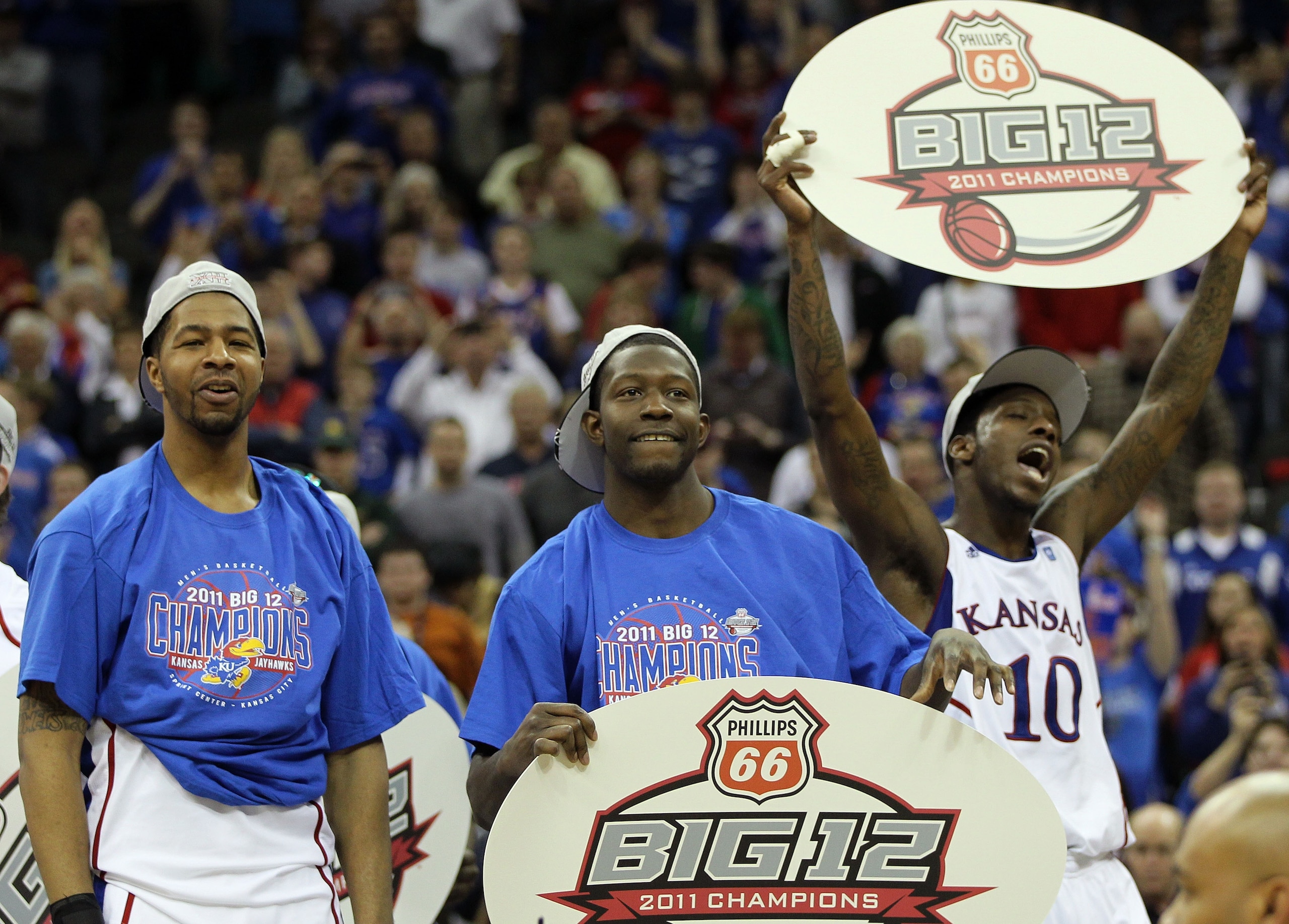 KANSAS CITY, MO - MARCH 12:  Markieff Morris #21, Elijah Johnson #15 and Tyshawn Taylor #10 of the Kansas Jayhawks celebrate after defeating the Texas Longhorns 85-73 to win the 2011 Phillips 66 Big 12 Men's Basketball Tournament championship game at Spri