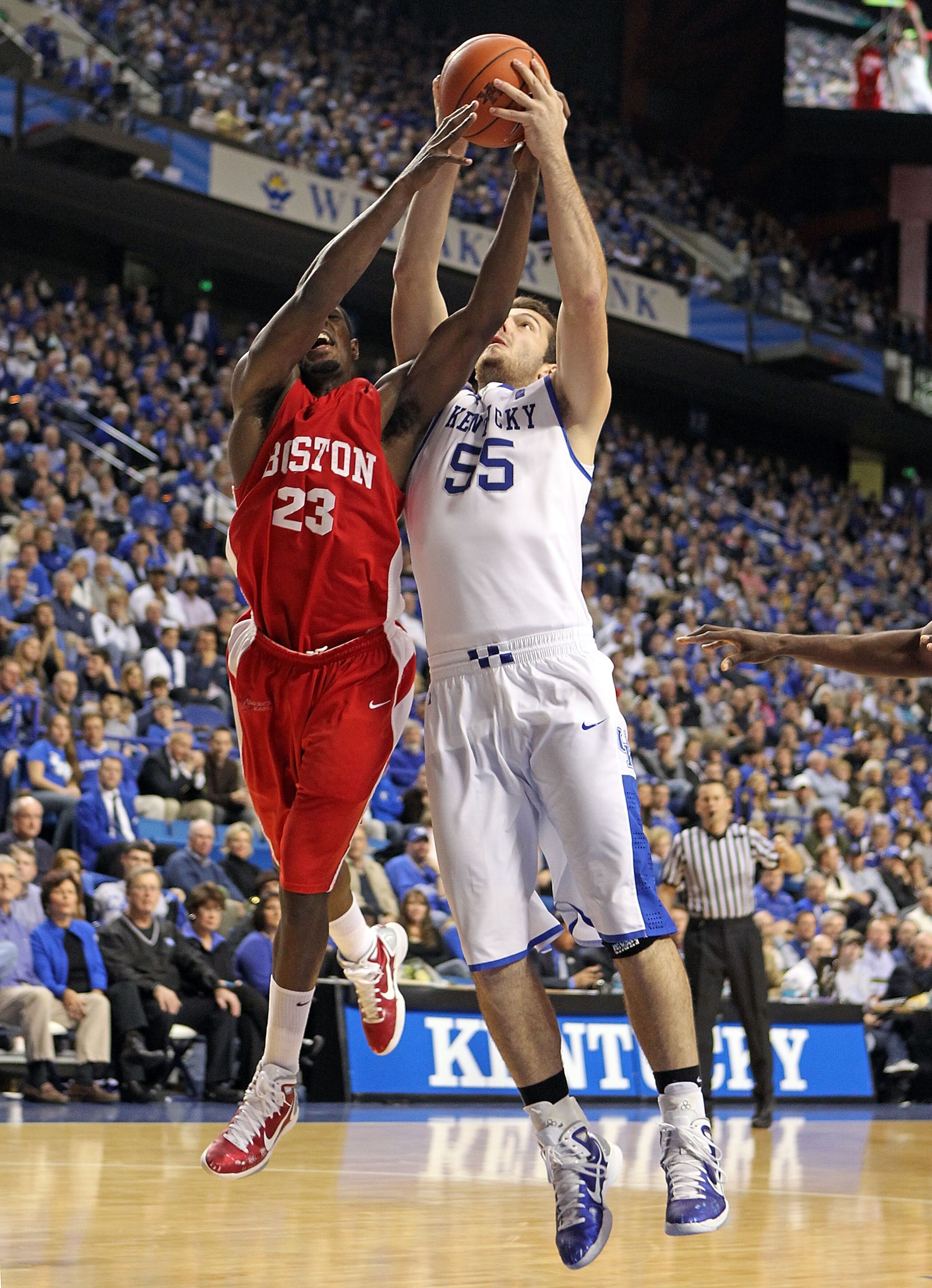 LEXINGTON, KY - NOVEMBER 30:  Josh Harrellson #55 of the Kentucky Wildcats and John Holland #23 of the Boston University Terriers battle for a rebound during the game on November 30, 2010 in Lexington, Kentucky. Kentucky won 91-57.  (Photo by Andy Lyons/G
