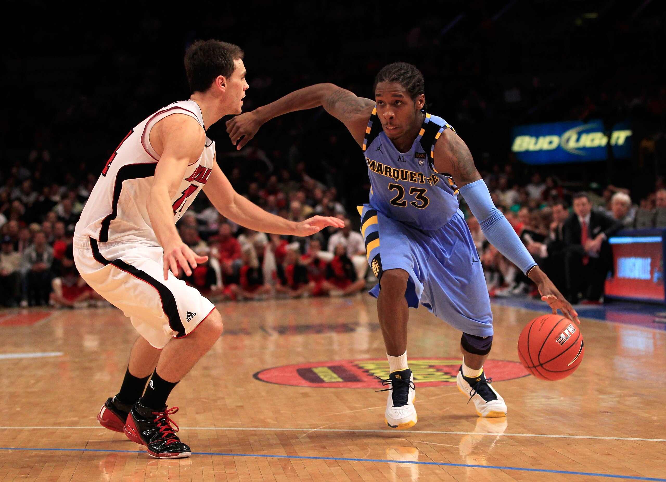 NEW YORK, NY - MARCH 10: Dwight Buycks #23 of the Marquette Golden Eagles drives with the ball against Kyle Kuric #14 of the Louisville Cardinals during the quarterfinals of the 2011 Big East Men's Basketball Tournament presented by American Eagle Outfitt