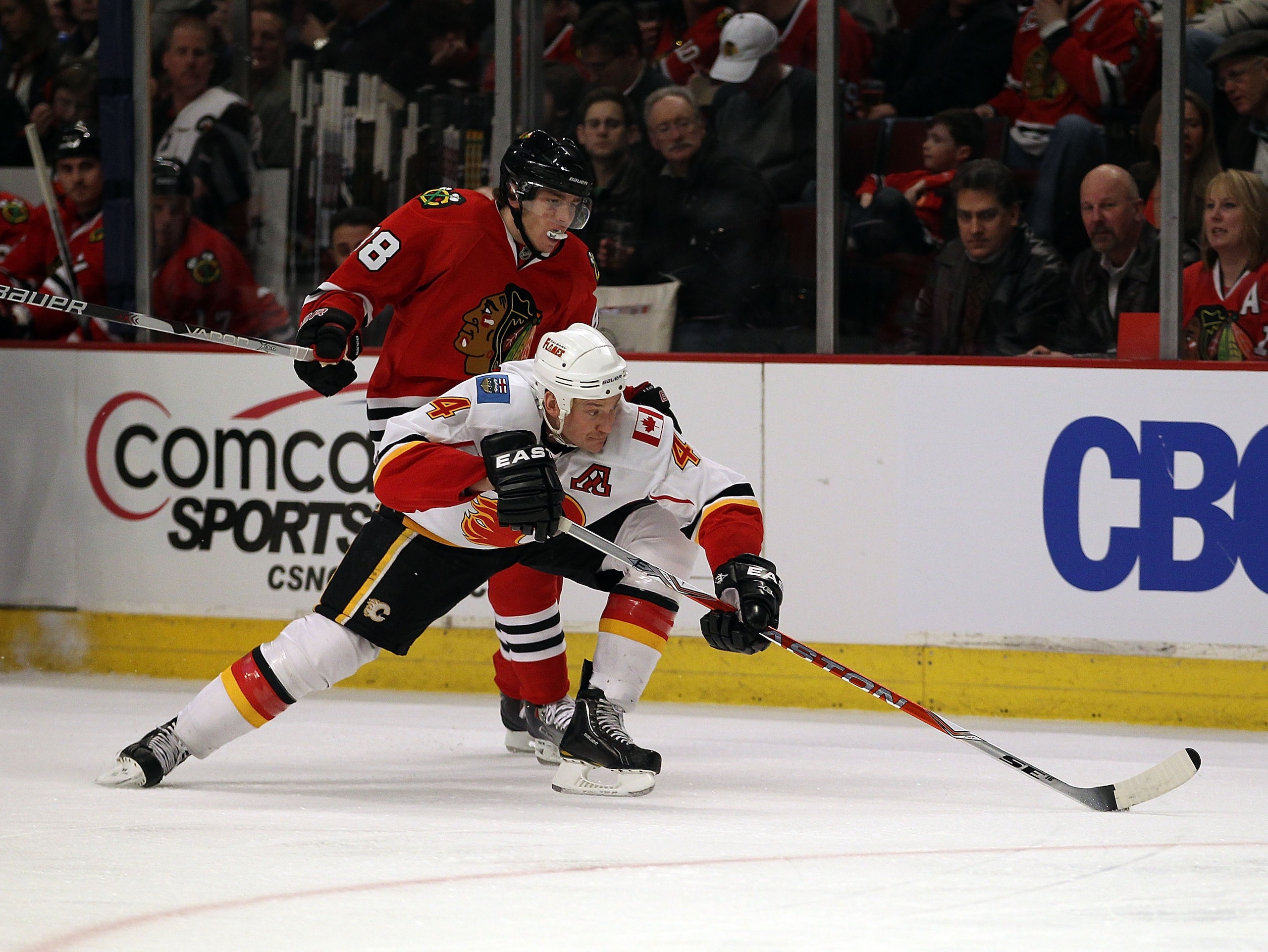 CHICAGO, IL - MARCH 02: Jay Bouwmeester #4 of the Calgary Flames controls the puck in front of Patrick Kane #88 of the Chicago Blackhawks at the United Center on March 2, 2011 in Chicago, Illinois. The Blackhawks defeated the Flames 6-4. (Photo by Jonatha