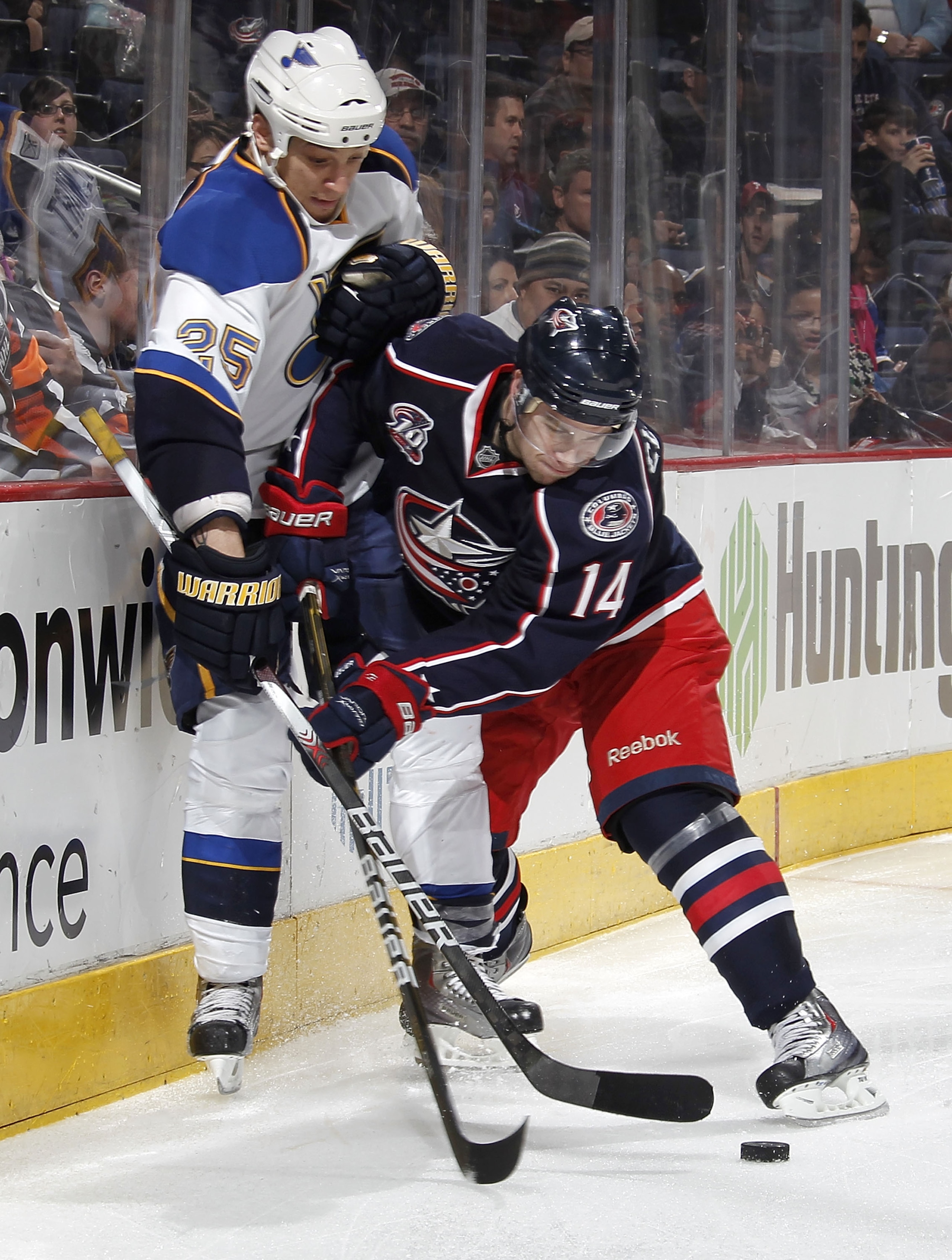 COLUMBUS, OH - MARCH 09: Grant Clitsome #14 of the Columbus Blue Jackets tries to control the puck in front of Chris Stewart #25 of the St. Louis Blues on March 9, 2011 at Nationwide Arena in Columbus, Ohio.  (Photo by Gregory Shamus/Getty Images)