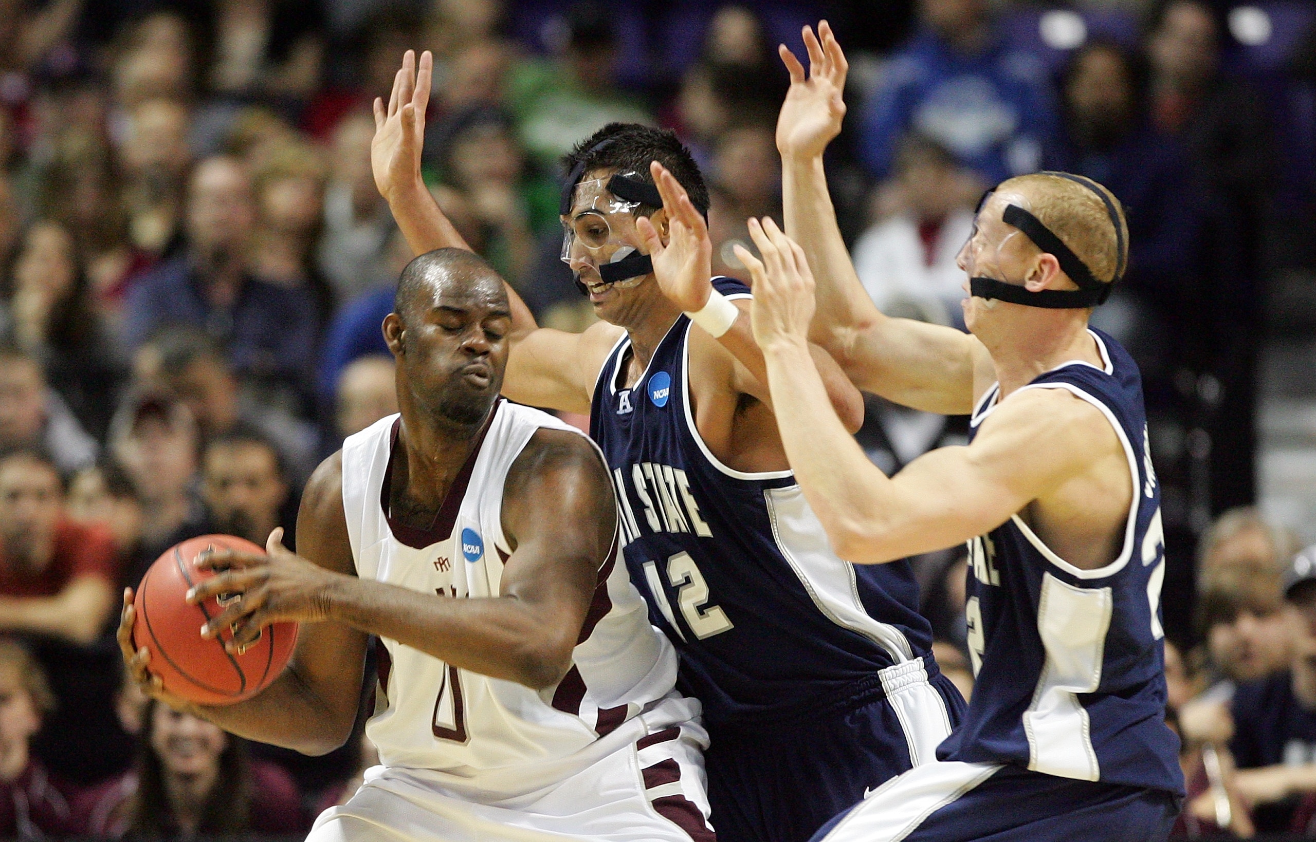 SPOKANE, WA - MARCH 19:  Bryan Davis #0 of the Texas A&M Aggies is defended by Tai Wesley #42 and Brady Jardine #22 of the Utah St. Aggies during the first round of the 2010 NCAA men's basketball tournament at Spokane Arena on March 19, 2010 in Spokane, W