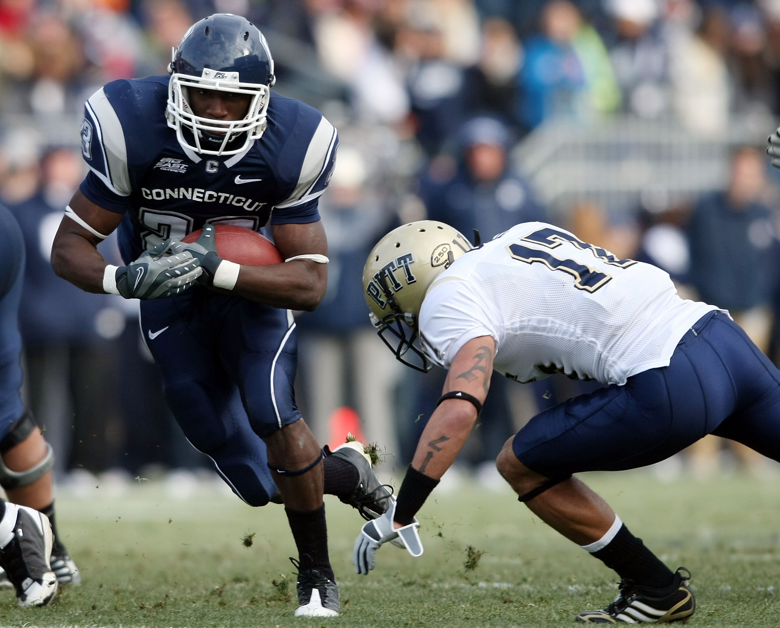 EAST HARTFORD, CT - DECEMBER 06:  Jordan Todman #23 of the Connecticut Huskies carries the ball as Aaron Berry #17 of the Pittsburgh Panthers defends on December 6, 2008 at Rentschler Field in East Hartford, Connecticut.  (Photo by Elsa/Getty Images)