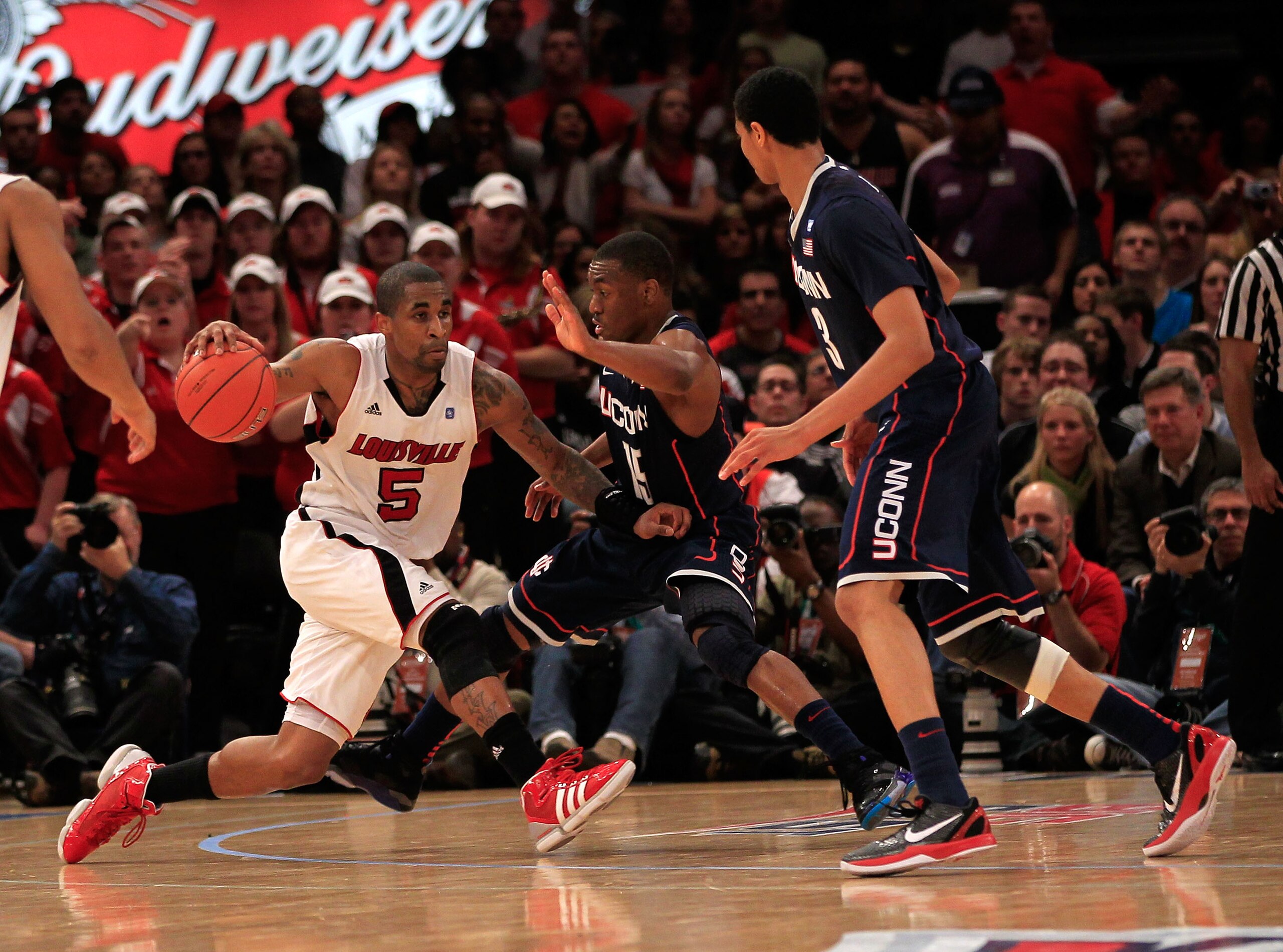 NEW YORK, NY - MARCH 12: Chris Smith #5 of the Louisville Cardinals drives with the ball against Kemba Walker #15 and Jeremy Lamb #3 of the Connecticut Huskies during the championship of the 2011 Big East Men's Basketball Tournament presented by American