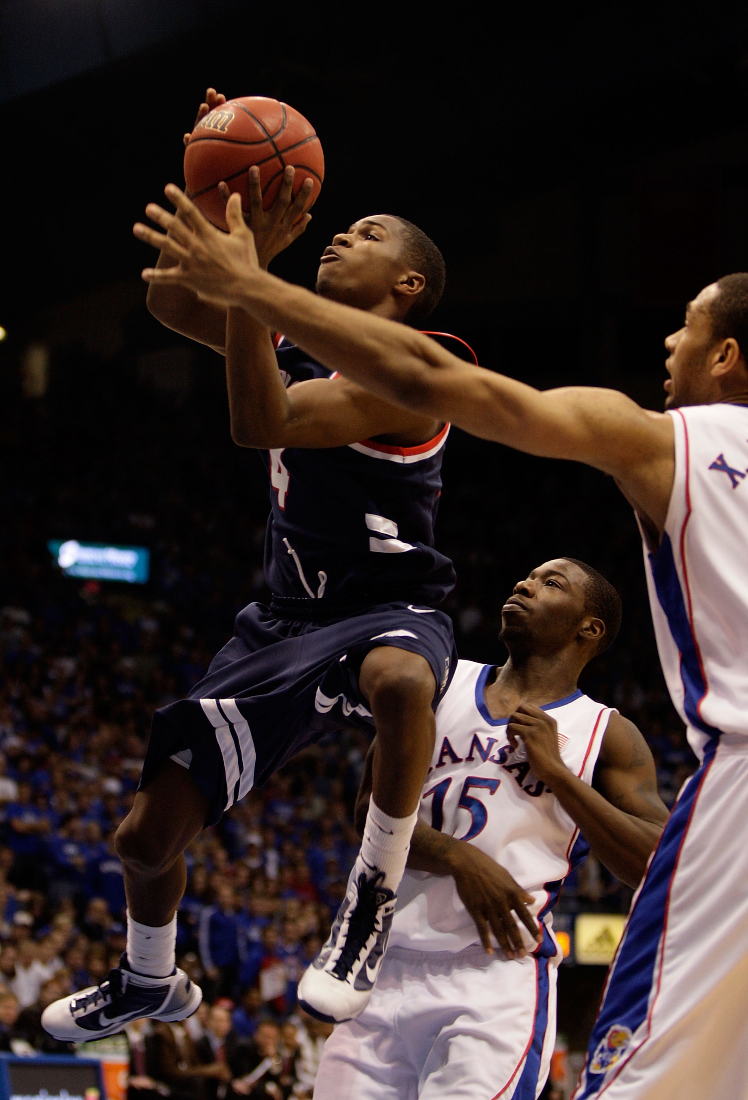 LAWRENCE, KS - DECEMBER 29:  Jonny Rice #4 of the Belmont Bruins shoots as Elijah Johnson #15 and Xavier Henry #1 of the Kansas Jayhawks defend during the game on December 29, 2009 at Allen Fieldhouse in Lawrence, Kansas.  (Photo by Jamie Squire/Getty Ima