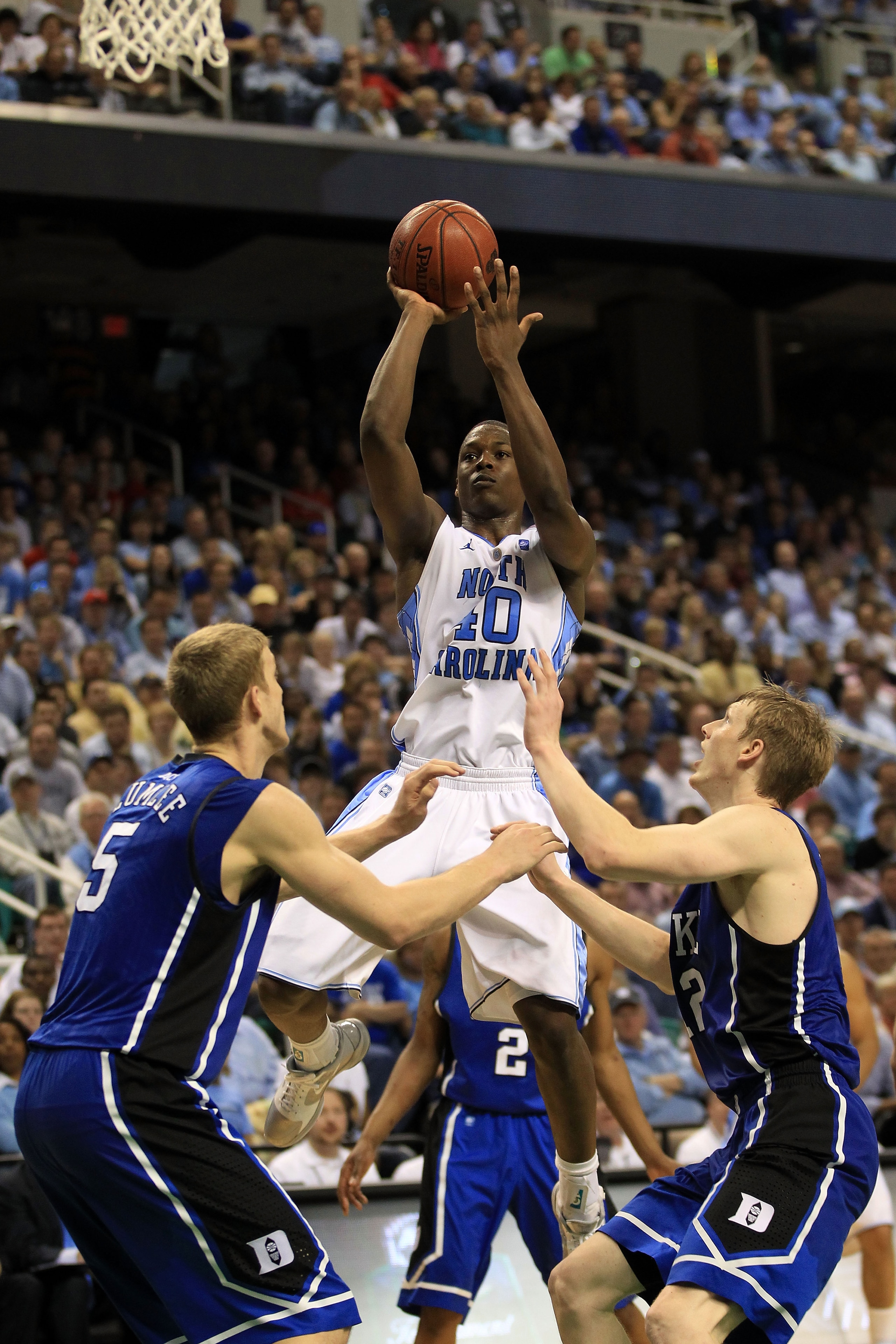 GREENSBORO, NC - MARCH 13:  Harrison Barnes #40 of the North Carolina Tar Heels shoots against Mason Plumlee #5 and Kyle Singler #12 of the Duke Blue Devils during the second half in the championship game of the 2011 ACC men's basketball tournament at the