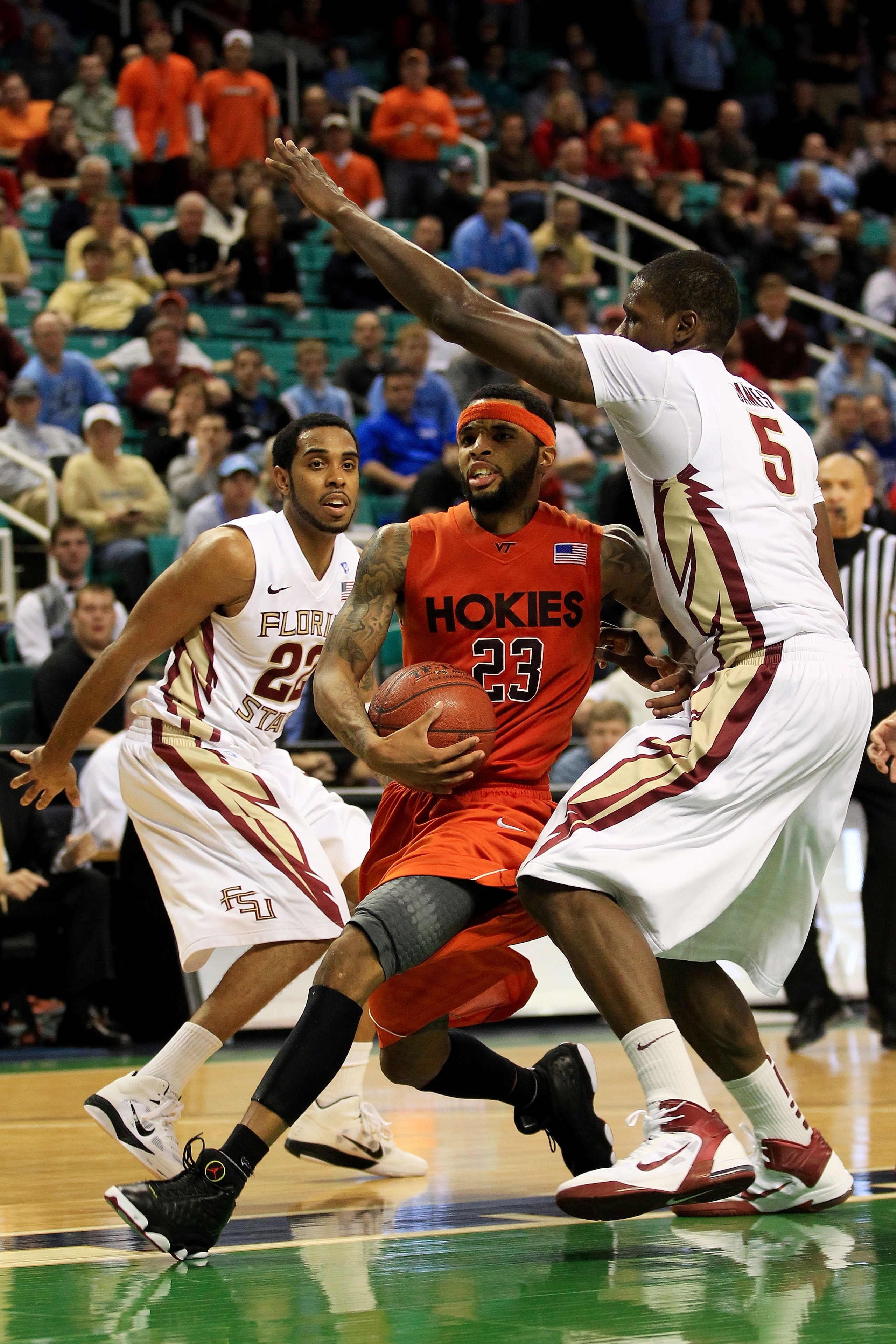 GREENSBORO, NC - MARCH 11:  Malcolm Delaney #23 of the Virginia Tech Hokies goes to shoot against Derwin Kitchen #22 and Bernard James #5 of the Florida State Seminoles during the second half in the quarterfinals of the 2011 ACC men's basketball tournamen