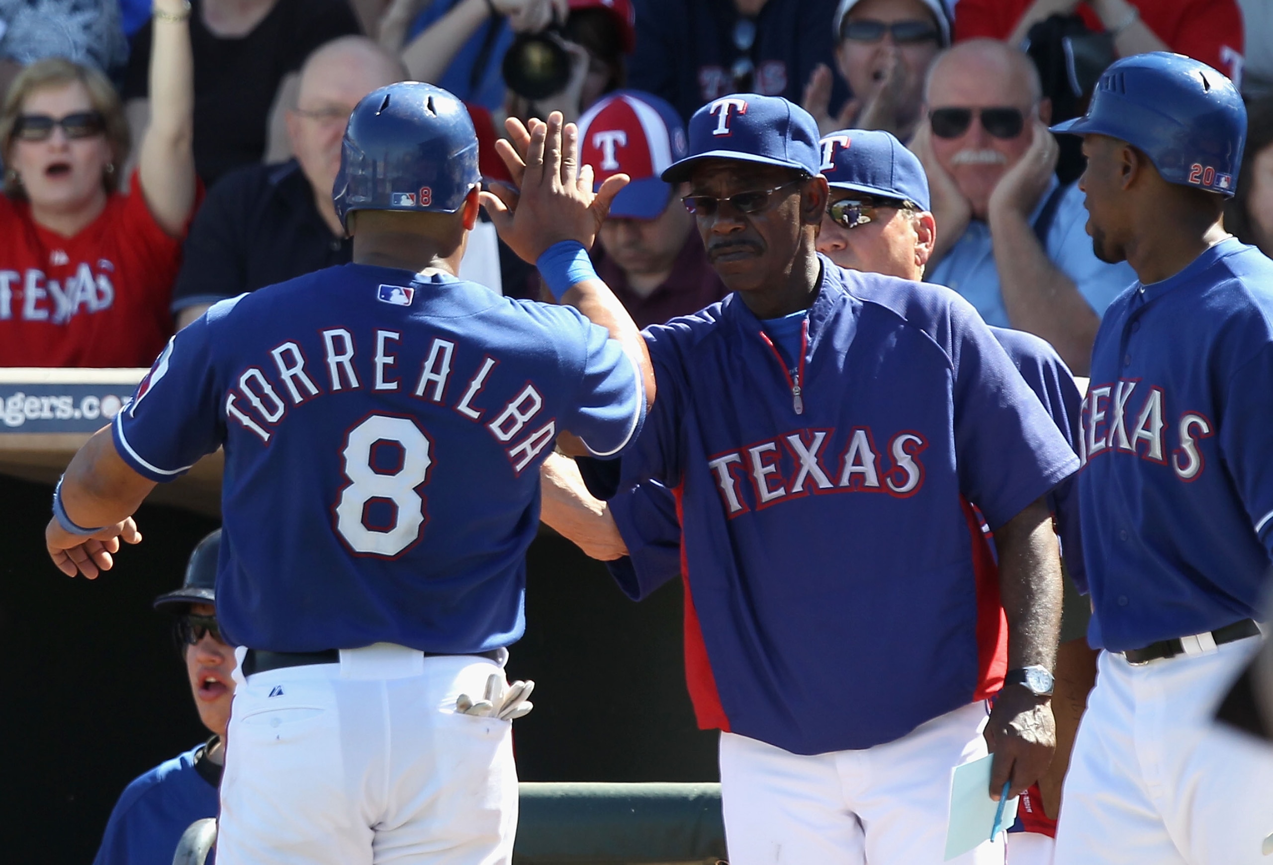 SURPRISE, AZ - MARCH 11:  Yorvit Torrealba #8 of the Texas Rangers high fives manager Ron Washington after scoring against the Cincinnati Reds during the second inning of the spring training game at Surprise Stadium on March 11, 2011 in Surprise, Arizona.
