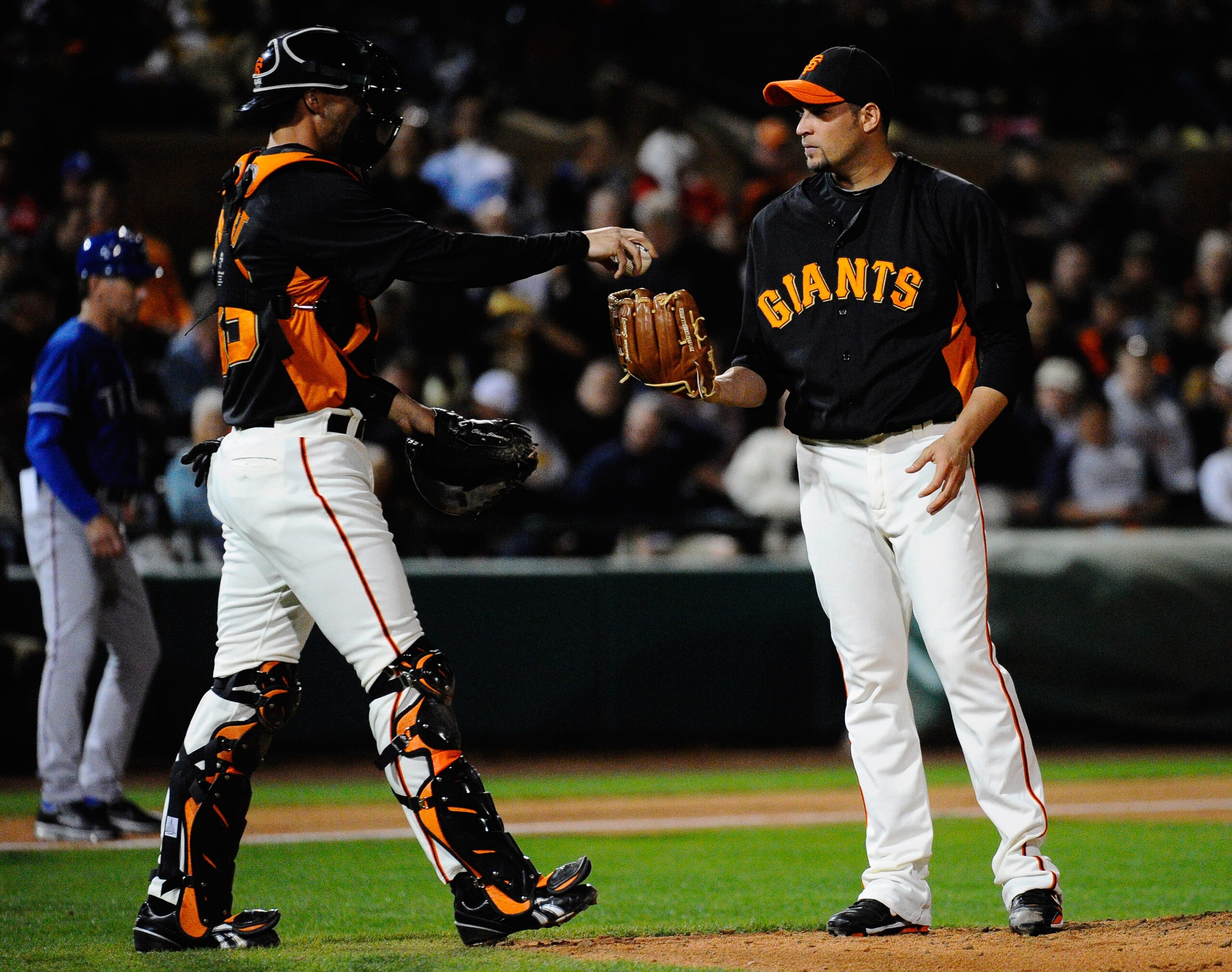 SCOTTSDALE, AZ - MARCH 07:  Pitcher Jonathan Sanchez #57 of the San Francisco Giants takes the ball from catcher Chris Stewart after the Texas Rangers scored in the first inning in the first meeting between the two teams since the World Series during the