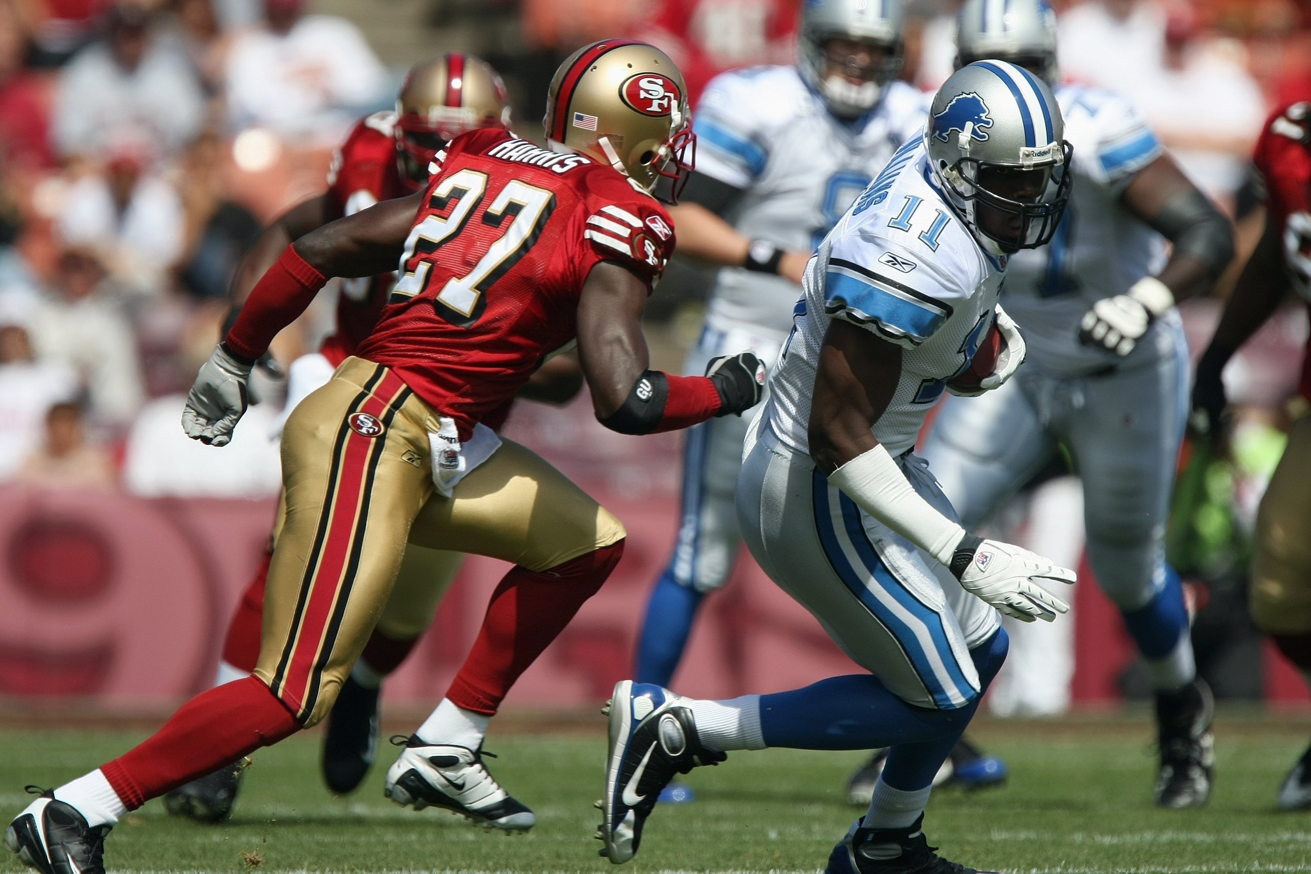 SAN FRANCISCO - SEPTEMBER 21:  Roy Williams #11 of the Detroit Lions runs with the ball against Walt Harris #27 of the San Francisco 49ers during the game on September 21, 2008 at Candlestick Park in San Francisco, California. (Photo by Jed Jacobsohn/Gett