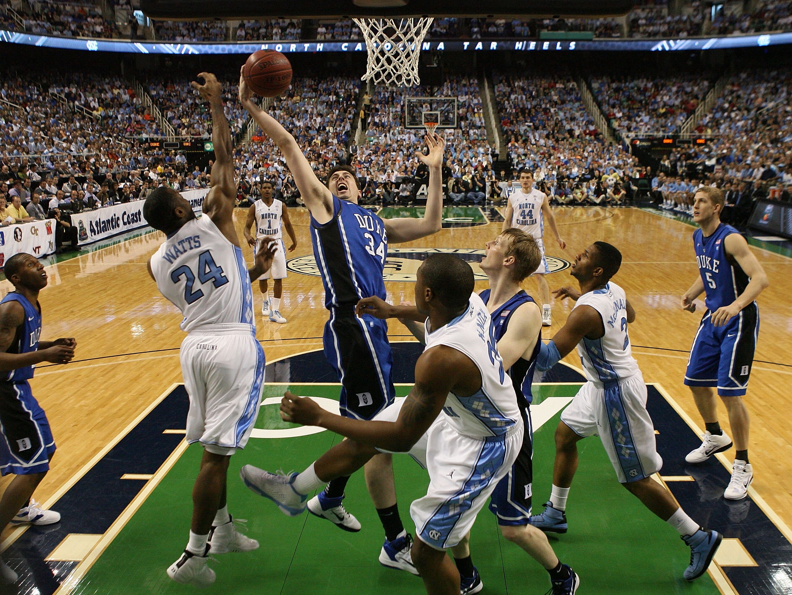 GREENSBORO, NC - MARCH 13:  Ryan Kelly #34 of the Duke Blue Devils fights for the ball against Justin Watts #24 of the North Carolina Tar Heels during the first half in the championship game of the 2011 ACC men's basketball tournament at the Greensboro Co