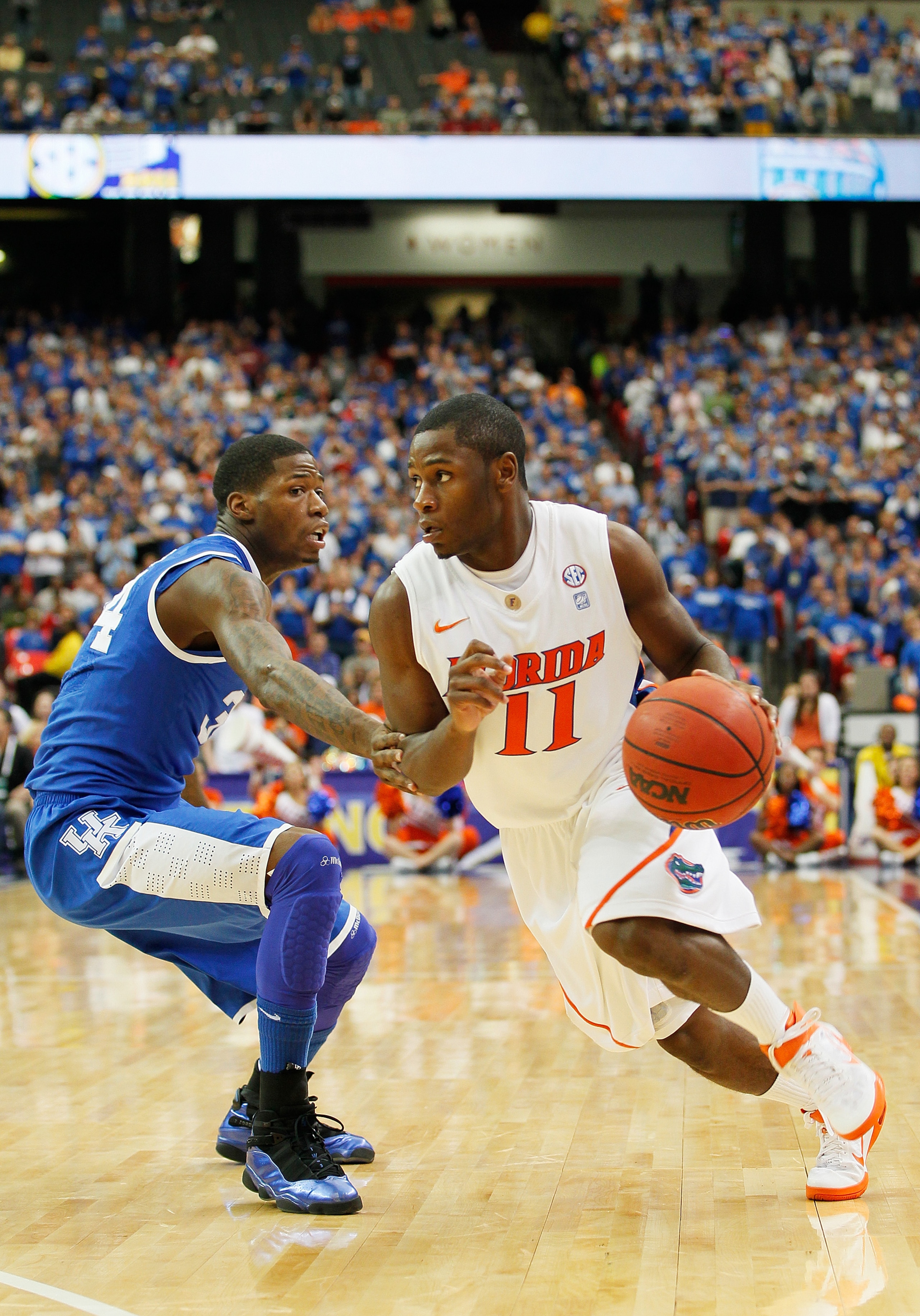 ATLANTA, GA - MARCH 13:  Erving Walker #11 of the Florida Gators drives past drives past DeAndre Liggins #34 of the Kentucky Wildcats during the championship game of the SEC Men's Basketball Tournament at Georgia Dome on March 13, 2011 in Atlanta, Georgia
