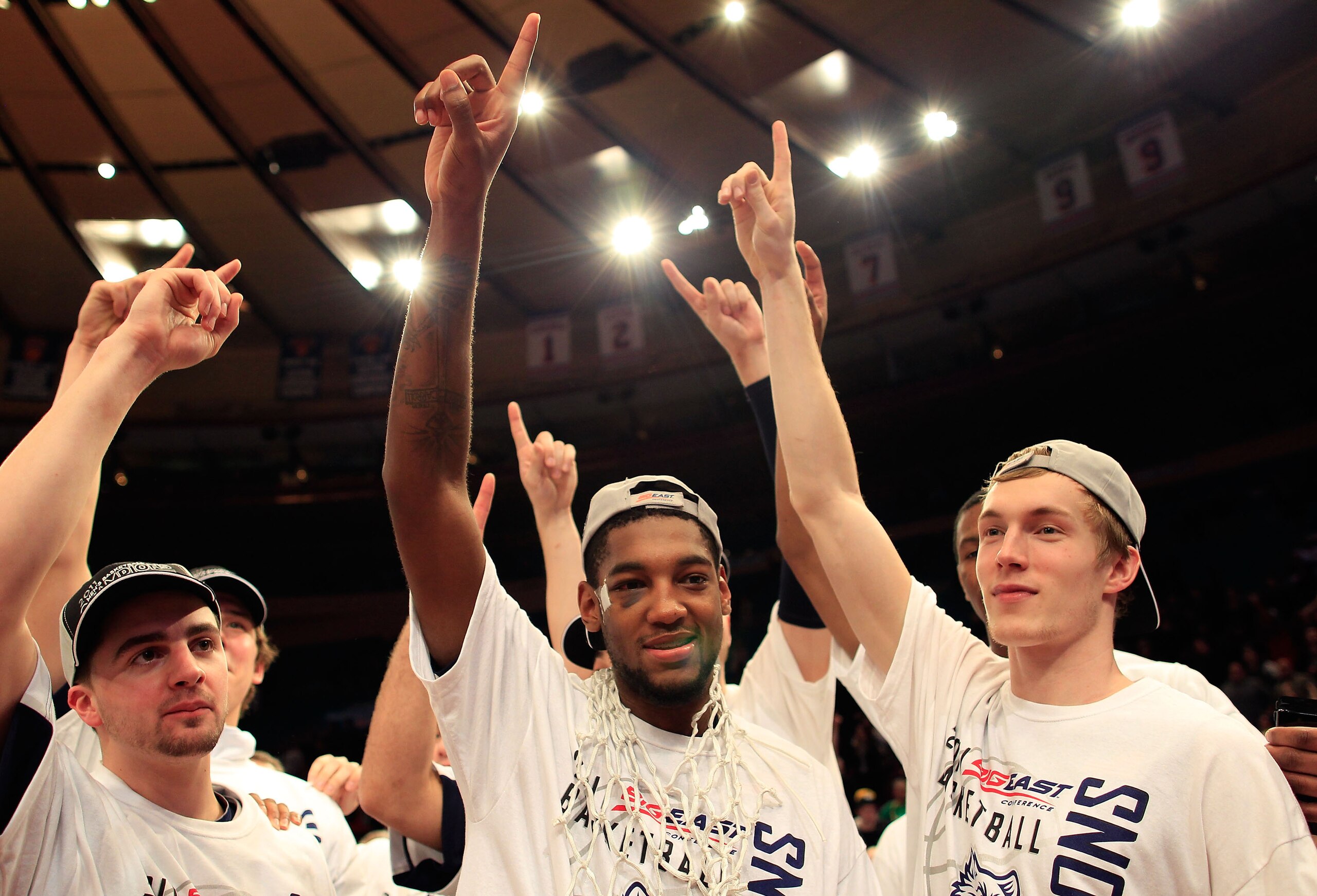 NEW YORK, NY - MARCH 12: Roscoe Smith (C) and Niels Giffey (R) celebrate after defeating the Louisville Cardinals during the championship of the 2011 Big East Men's Basketball Tournament presented by American Eagle Outfitters at Madison Square Garden on M