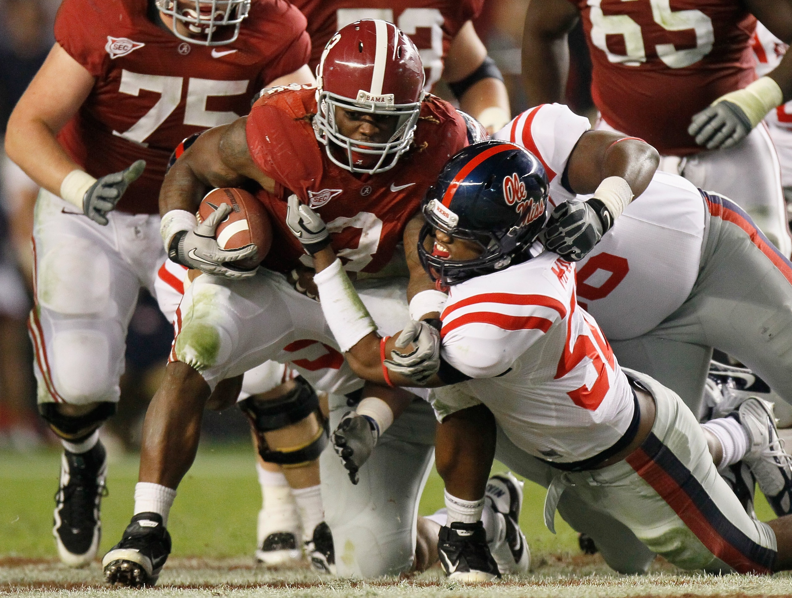 TUSCALOOSA, AL - OCTOBER 16:  Trent Richardson #3 of the Alabama Crimson Tide pushes for more yardage against Mike Marry #52 and Lawon Scott #96 of the Ole Miss Rebels at Bryant-Denny Stadium on October 16, 2010 in Tuscaloosa, Alabama.  (Photo by Kevin C.