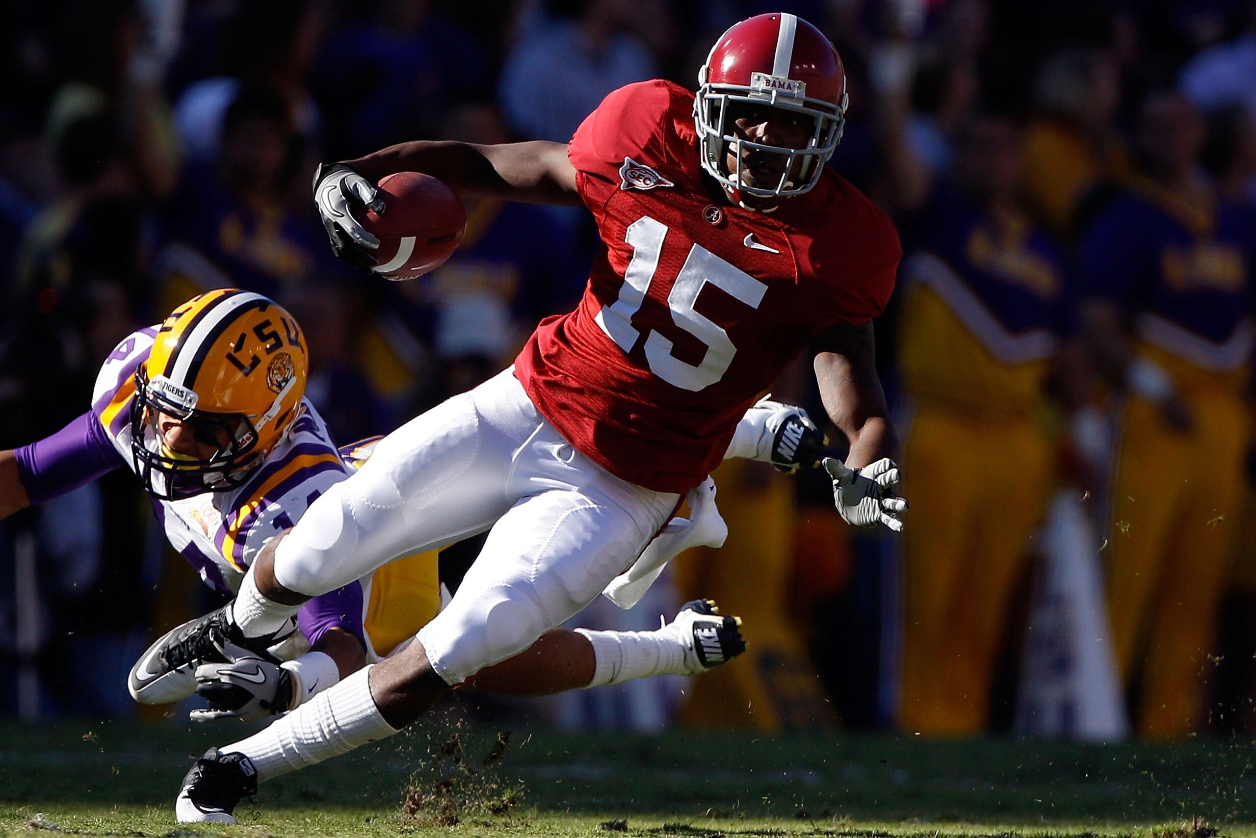 BATON ROUGE, LA - NOVEMBER 06:  Darius Hanks #15 of the Alabama Crimson Tide avoids a tackle by Tyrann Mathieu #14 of the Louisiana State University Tigers at Tiger Stadium on November 6, 2010 in Baton Rouge, Louisiana.  (Photo by Chris Graythen/Getty Ima