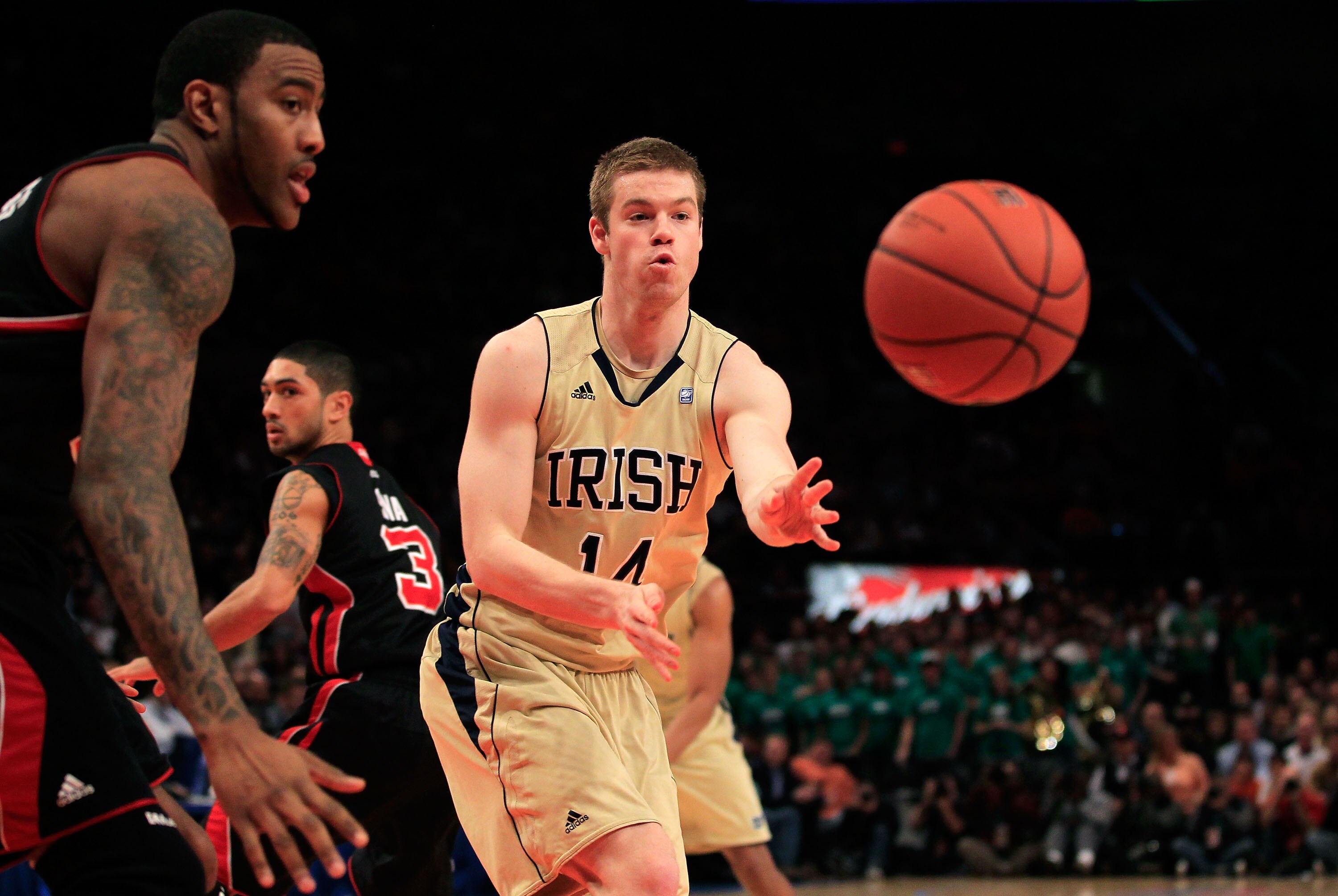 NEW YORK, NY - MARCH 11: Scott Martin #14 of the Notre Dame Fighting Irish passes the ball against the Louisville Cardinals during the semifinals of the 2011 Big East Men's Basketball Tournament presented by American Eagle Outfitters at Madison Square Gar