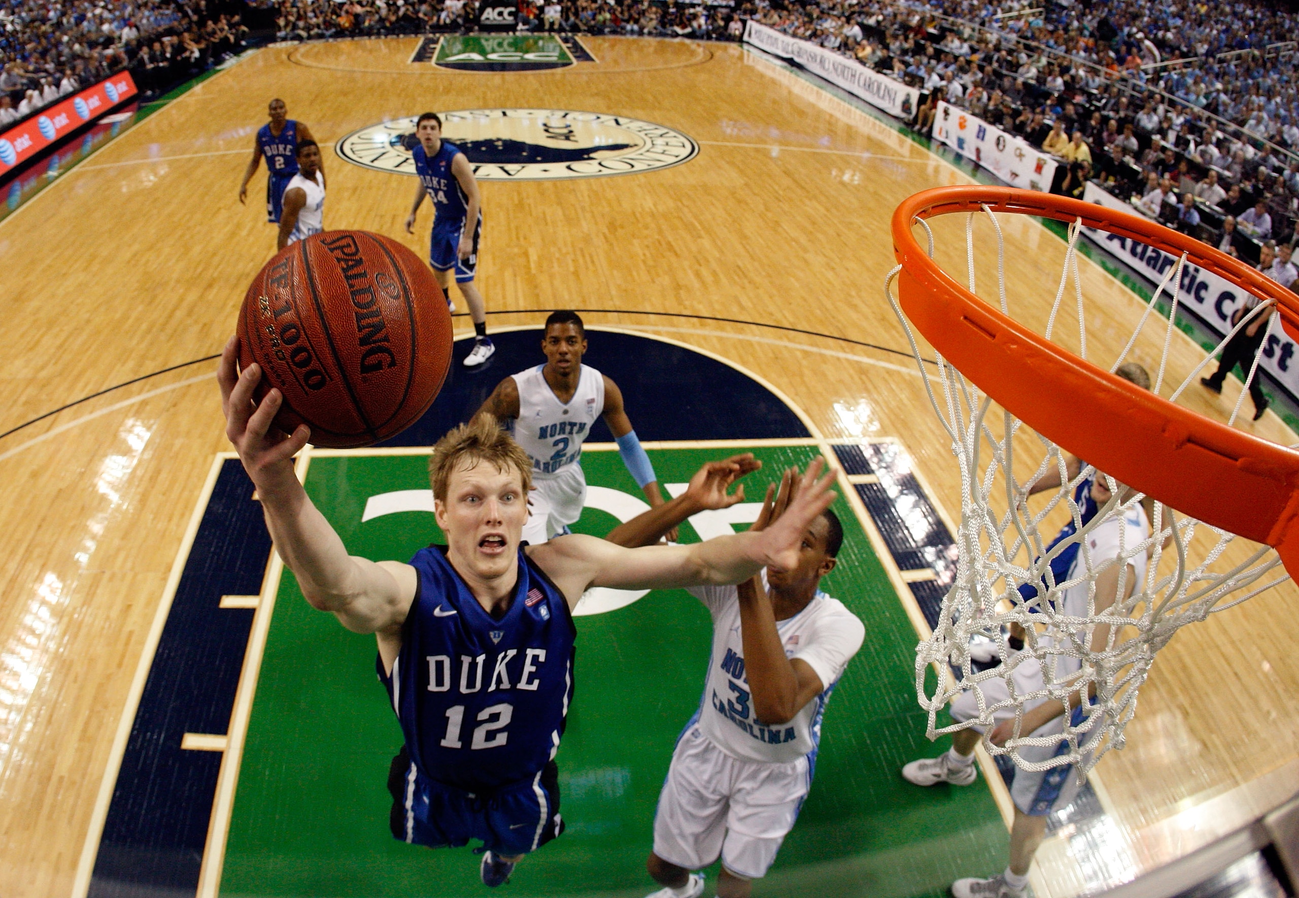 GREENSBORO, NC - MARCH 13:  Kyle Singler #12 of the Duke Blue Devils shoots against John Henson #31 of the North Carolina Tar Heels in the championship game of the 2011 ACC men's basketball tournament at the Greensboro Coliseum on March 13, 2011 in Greens