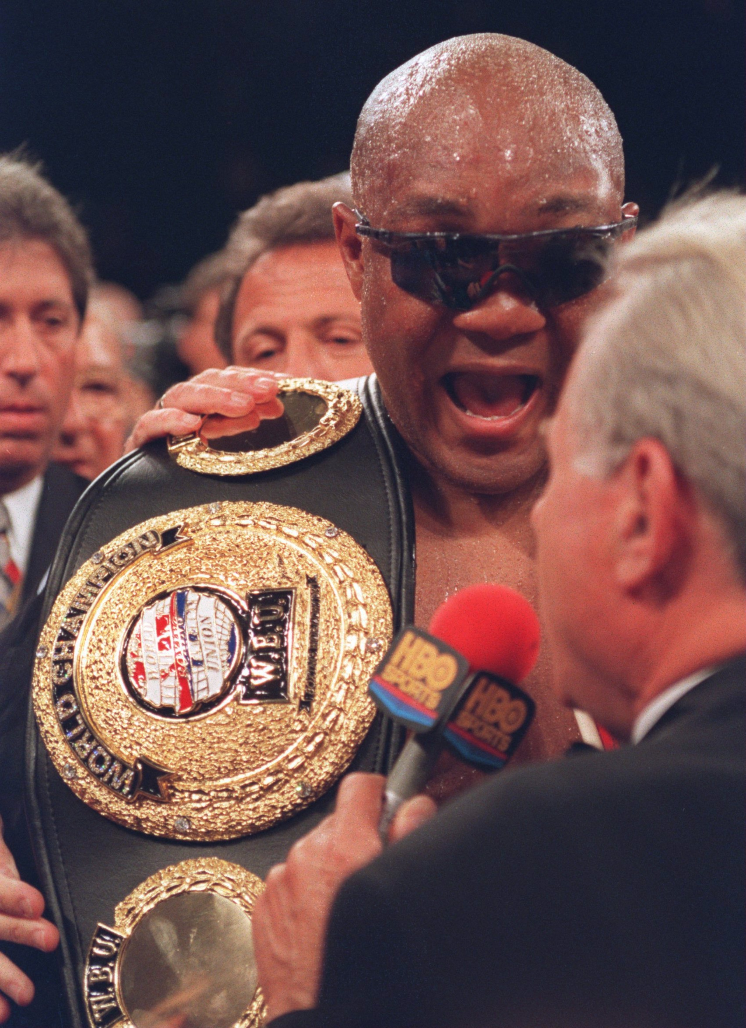 22 APR 1995:  HEAVYWEIGHT CHAMPION GEORGE FOREMAN DISCUSSES HIS VICTORY OVER GERMAN AXEL SCHULTZ IMMEDIATLY FOLLOWING THEIR IBF TITLE BOUT AT THE MGM GRAND HOTEL IN LAS VEGAS, NEVADA. FOREMAN WEARS SUNGLASSES TO SHIELD HIS BADLY SWOLLEN LEFT EYE.  Mandato