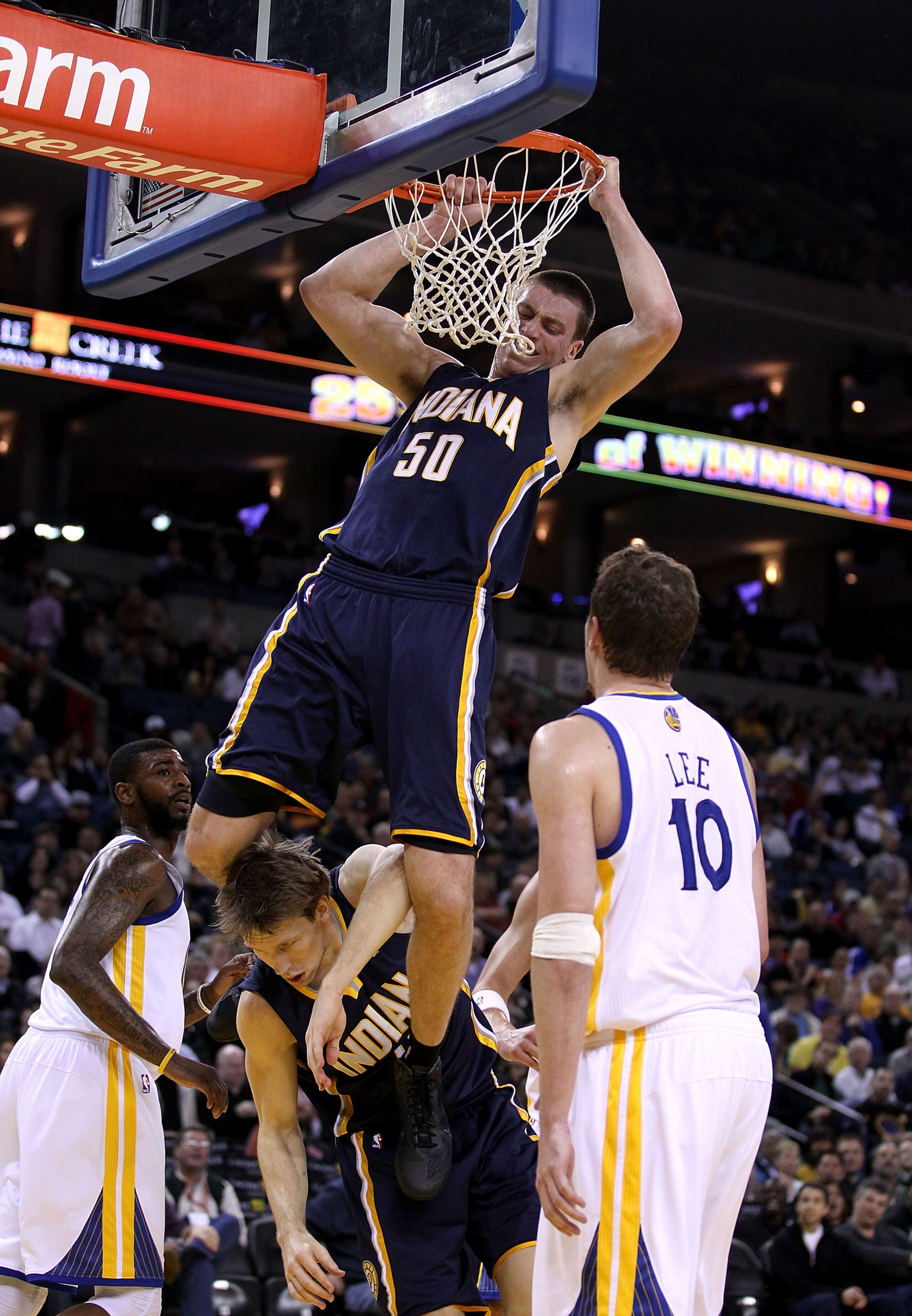 OAKLAND, CA - JANUARY 19: Tyler Hansbrough #50 of the Indiana Pacers hangs on the rim after he dunked the ball so he doesn't land on Mike Dunleavy #17 during their game against the Golden State Warriors at Oracle Arena on January 19, 2011 in Oakland, Cal OAKLAND, CA - JANUARY 19: Tyler Hansbrough #50 of the Indiana Pacers hangs on the rim after he dunked the ball so he doesn't land on Mike Dunleavy #17 during their game against the Golden State Warriors at Oracle Arena on January 19, 2011 in Oakland, Cal