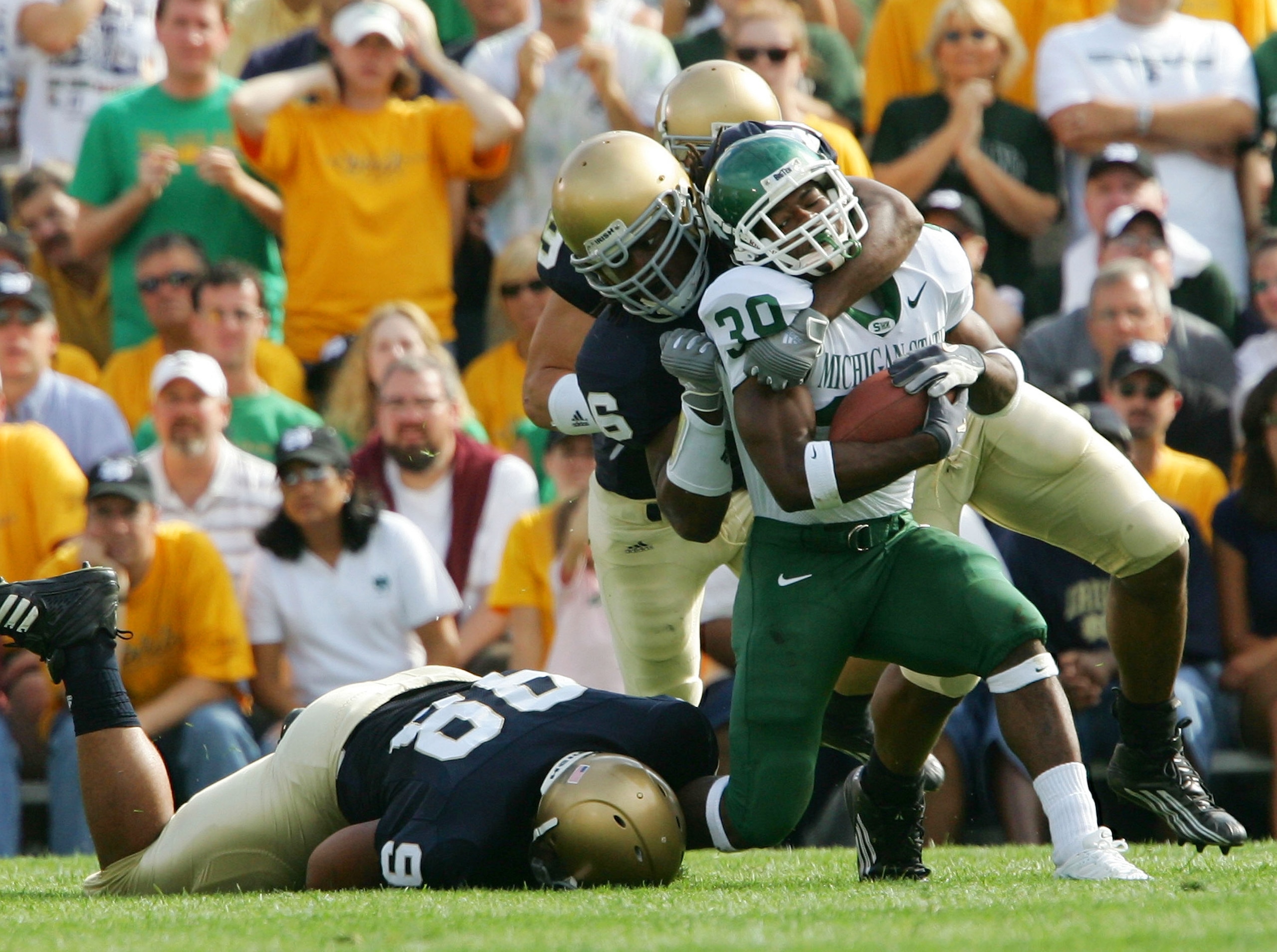 SOUTH BEND, IN - SEPTEMBER 17:  Running back Javon Ringer #39 of the Michigan State Spartans is pulled down by defensive back Ray Herring #6 of the Notre Dame Fighting Irish on September 17, 2005 at Notre Dame Stadium in South Bend, Indiana.  (Photo by El