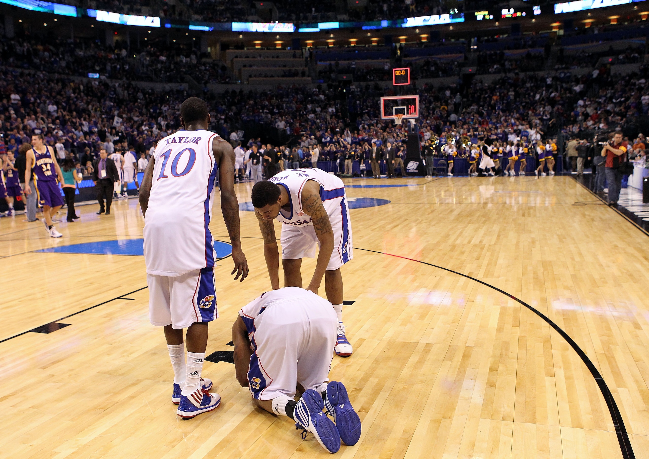 OKLAHOMA CITY - MARCH 20:  (L-R) Tyshawn Taylor #10, Marcus Morris #22 and Markieff Morris #21 of the Kansas Jayhawks remain on the floor dejected after they lost 69-67 against the Northern Iowa Panthers during the second round of the 2010 NCAA men's bask
