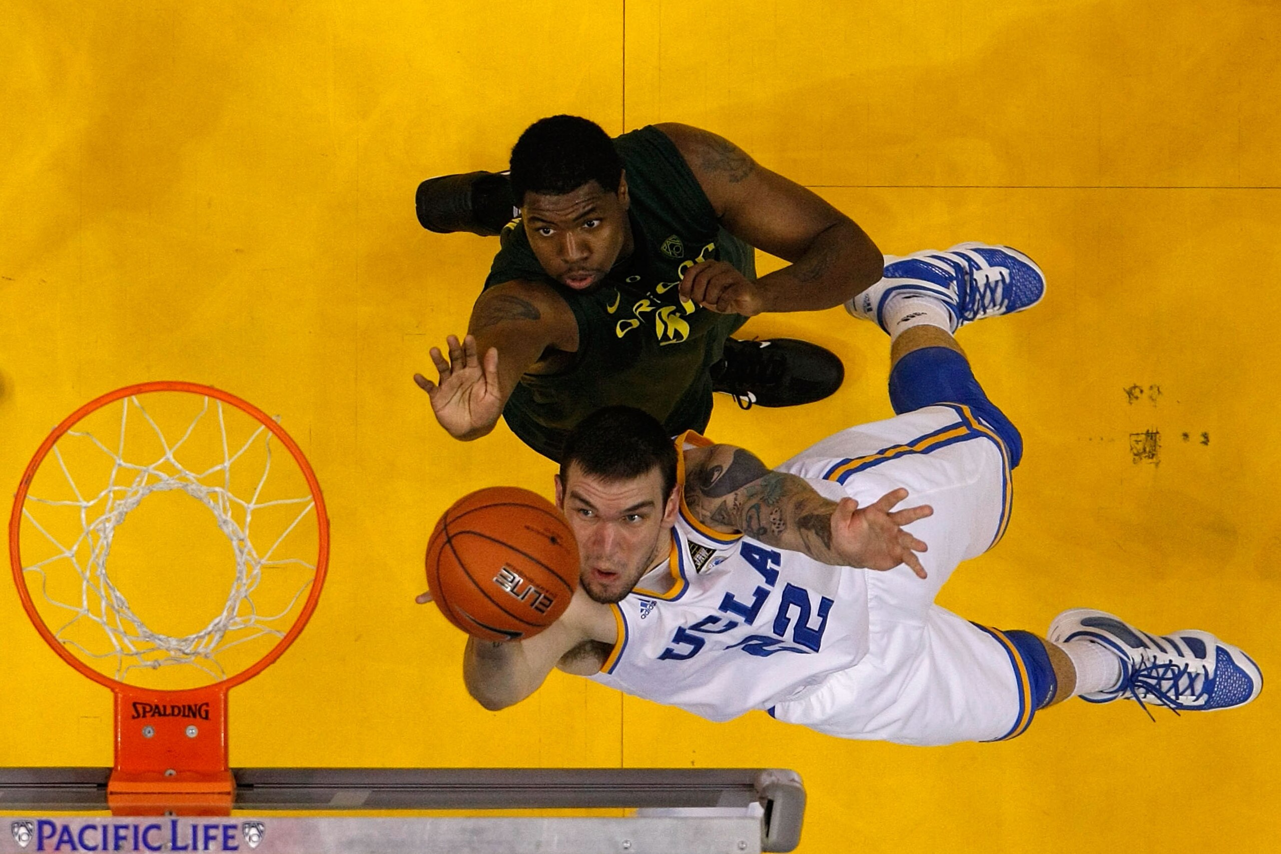 LOS ANGELES, CA - MARCH 10:  Reeves Nelson #22 of the UCLA Bruins lays the ball up in front of Joevan Catron #34 of the Oregon Ducks in the quarterfinals of the 2011 Pacific Life Pac-10 Men's Basketball Tournament at Staples Center on March 10, 2011 in Lo